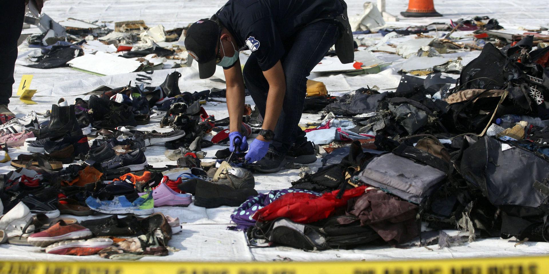 En utredare går igenom saker som hittats efter kraschen i Indonesien. Arkivbild.