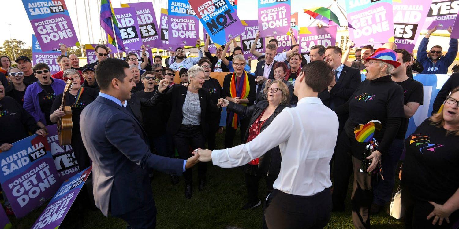 Förespråkare av samkönade äktenskap jublar utanför parlamentsbyggnaden i Canberra i samband med att lagen om att tillåta sådana klubbades tidigare i veckan.