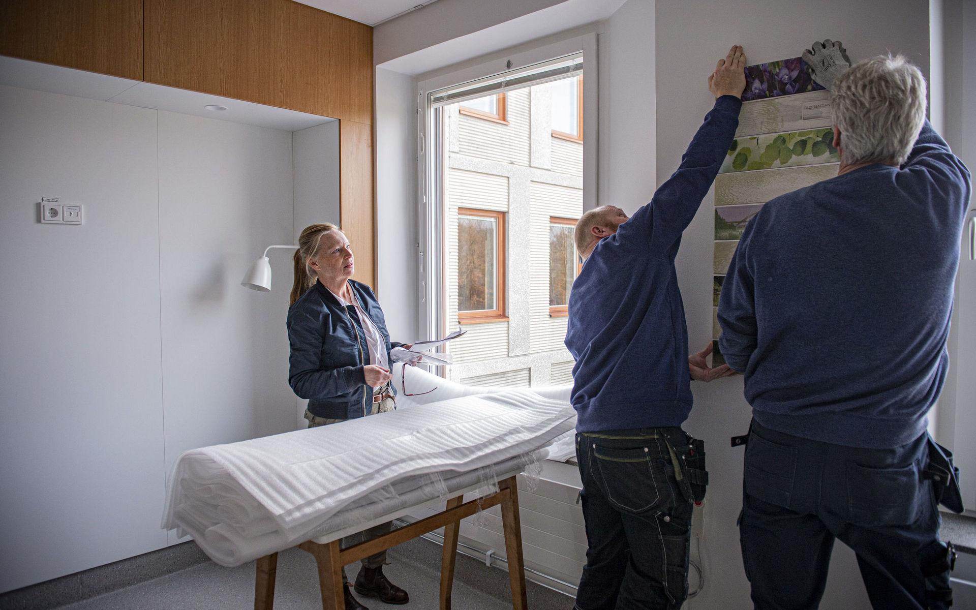 Konsten på plats. Konstnären Agneta Spångberg får hjälp av två snickare att montera de keramiska konstverken i patientrummen i Kungälvs sjukhus nya lokaler. 