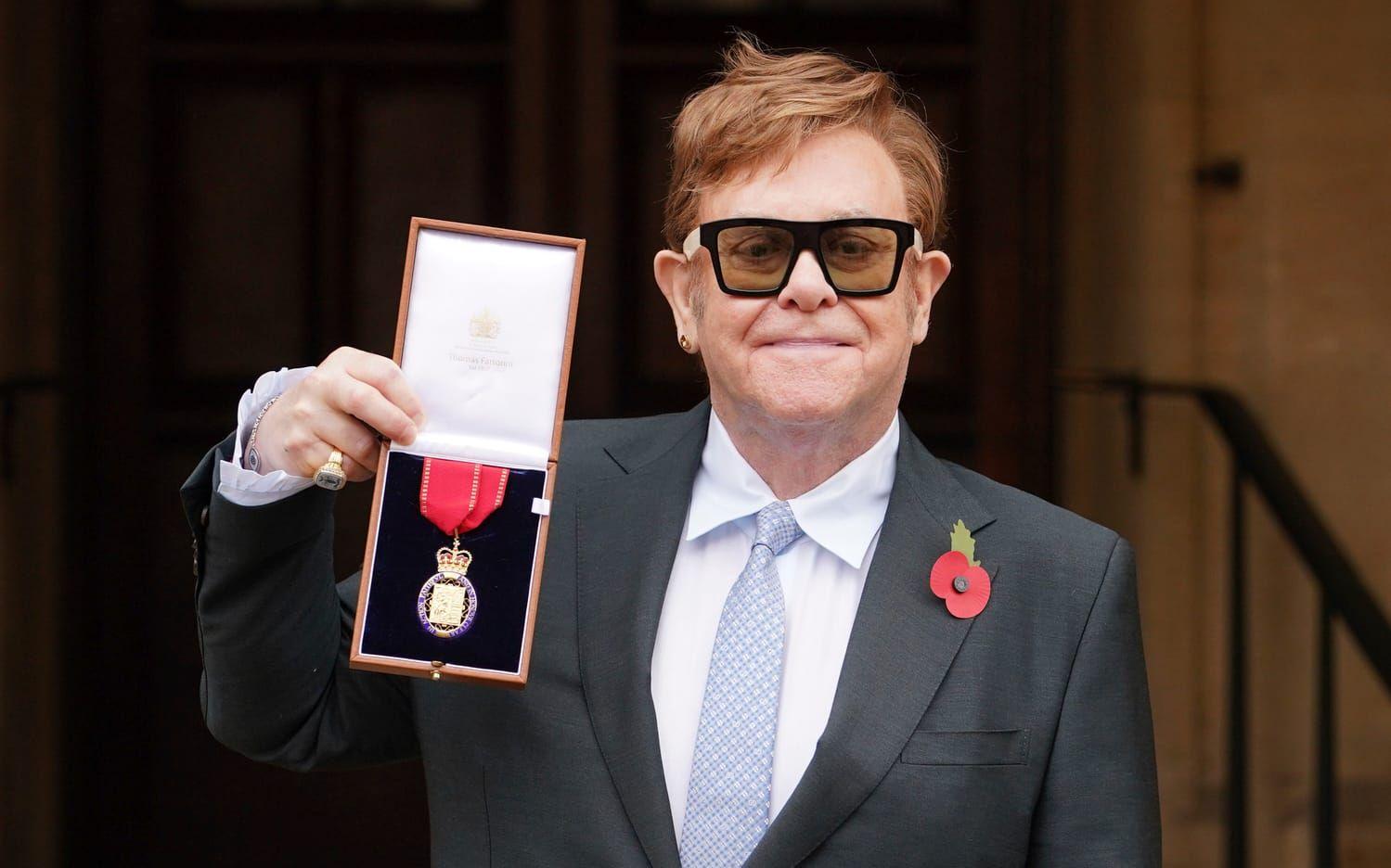 Sir Elton John fick sin Order of the Companions of Honour for services to Music and to Charity i Windsor Castle, i 2021. Nu sörjer han drottningen. 