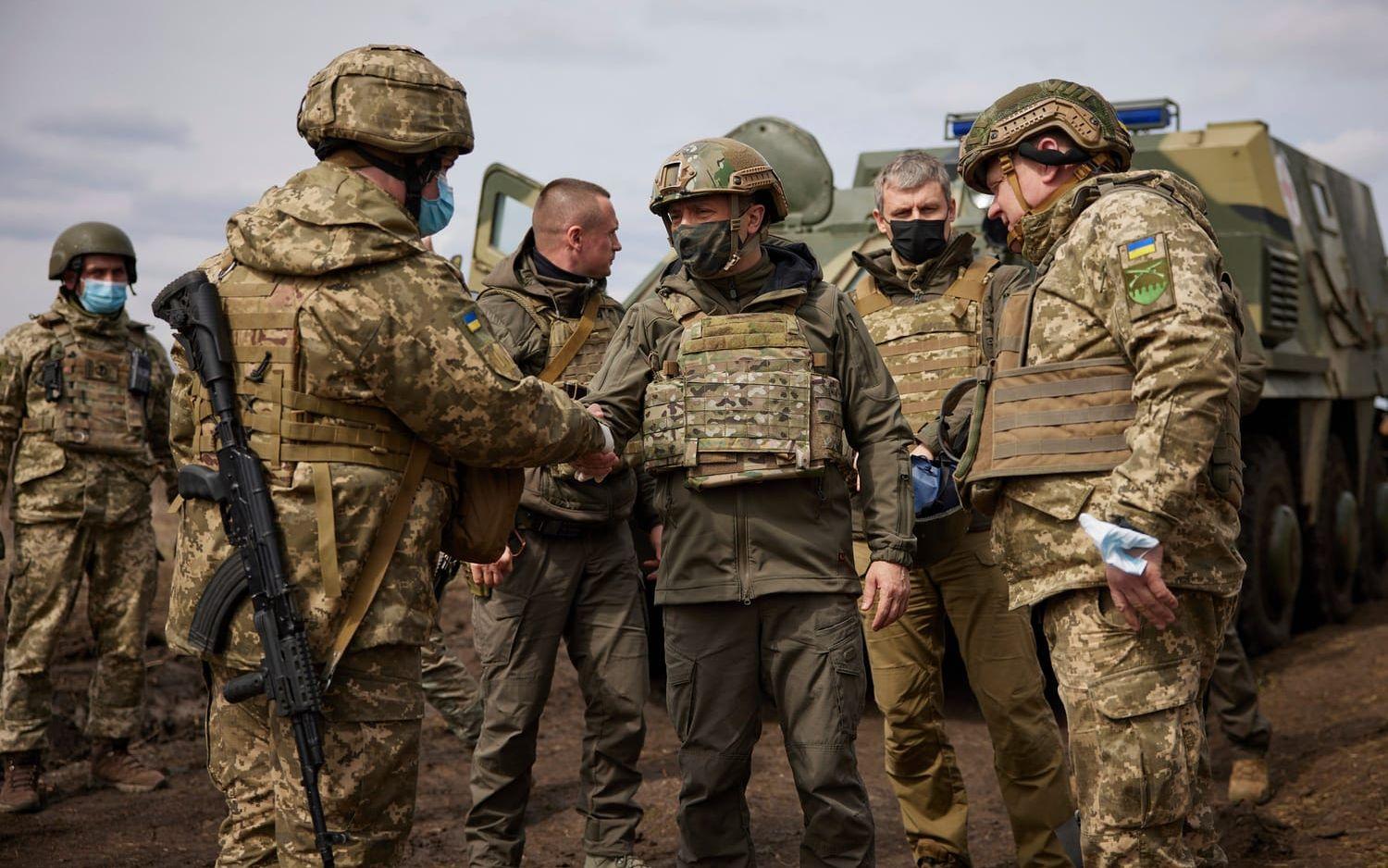 Ukrainas president Volodymyr Zelenskyj (trea från höger) skakar hand med en ukrainsk soldat i konfliktområdet i östra Ukraina. Arkivbild.