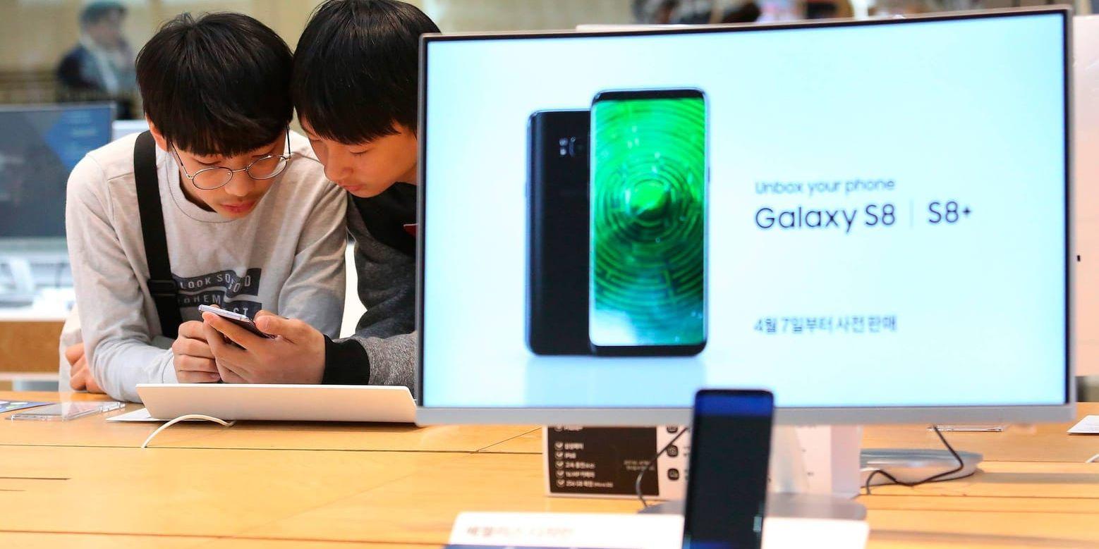 Ungdomar studerar mobiler i en av Samsungs affärer i Seoul i hemlandet Sydkorea.