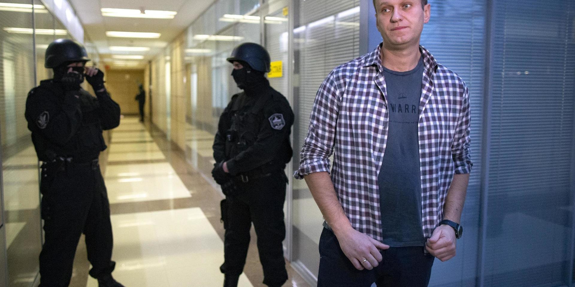 Oppositionsledaren Navalnyj framför säkerhetspoliser på vakt vid hans ideella och nedläggningshotade stiftelse för att bekämpa korruption i Moskva tidigare i sommar.