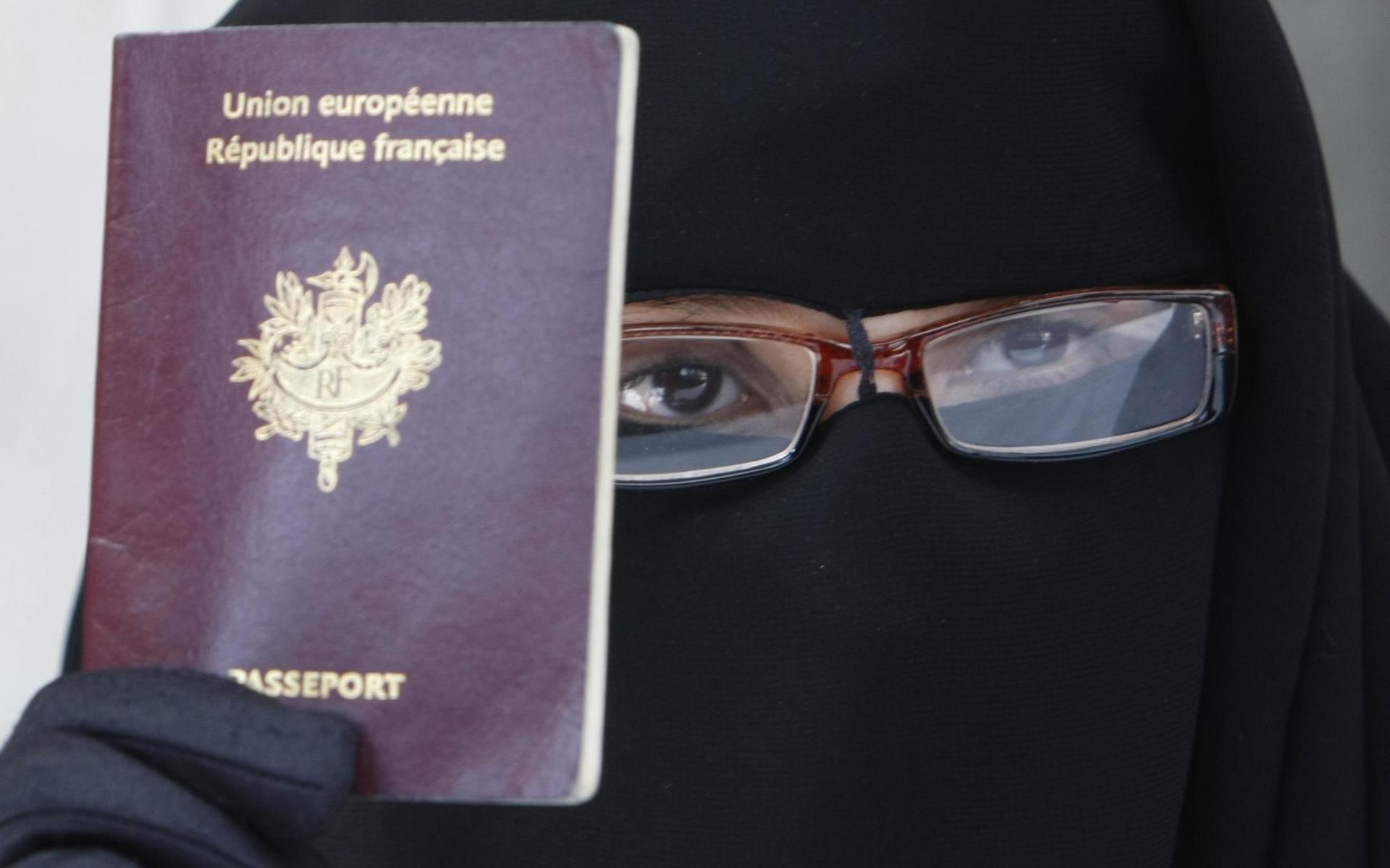 En kvinna protesterar mot den nya lagen mot slöjor som täcker ansiktet som infördes i Frankrike 2010, och återigen diskuteras efter att ansiktsmask blivit obligatoriskt. 