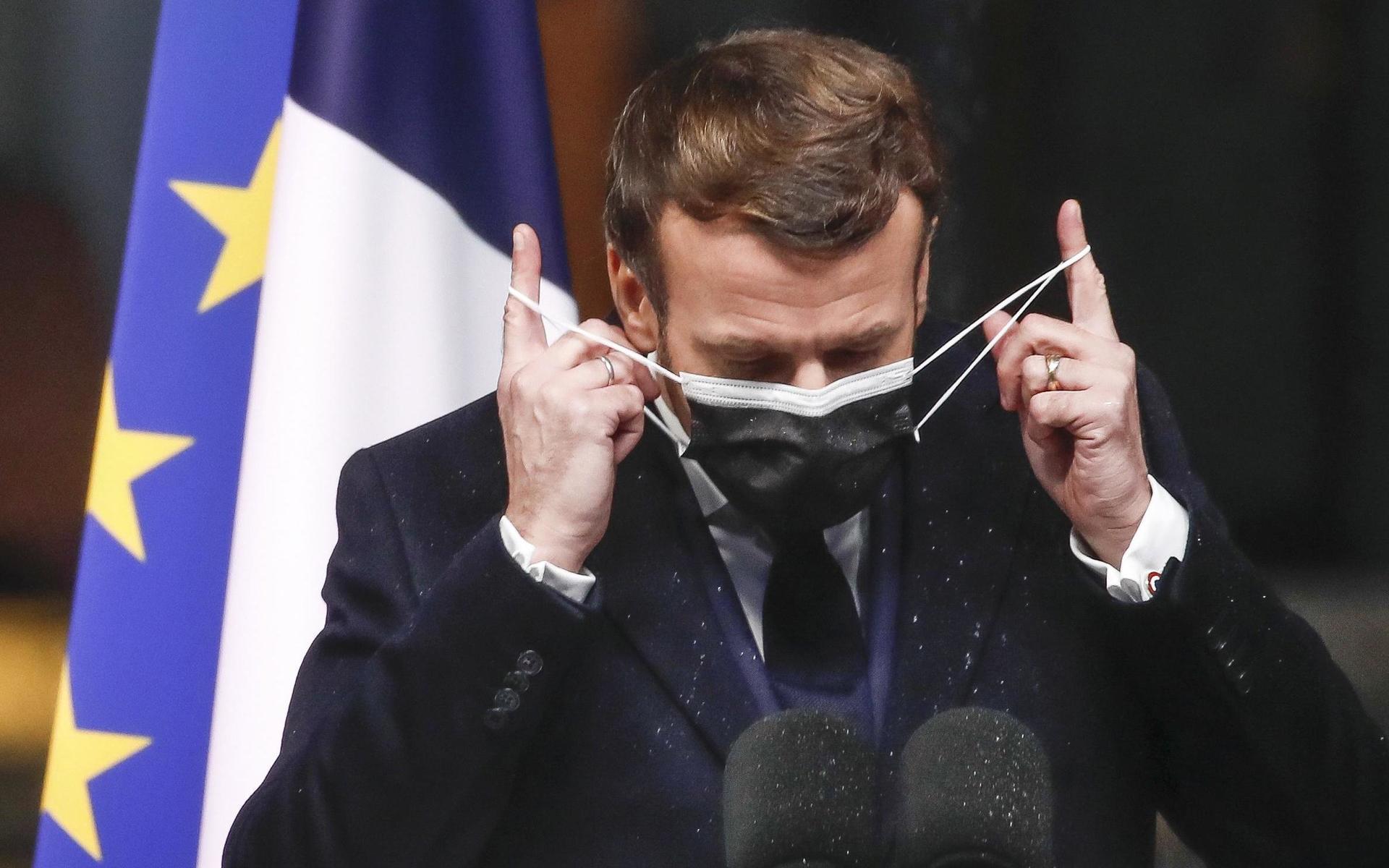 Den franska presidenten Emmanuel Macron tar av sig masken inför ett tal i januari i år. 