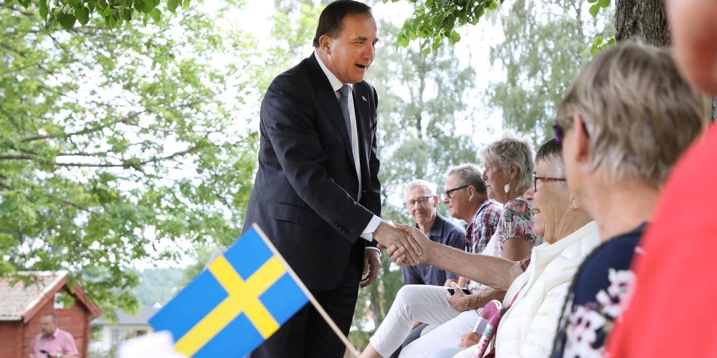 Statsminister Stefan Löfven (S) hälsar på nationaldagsfirare vid hembygdsgården i Mullsjö. Hans tal fick en vacker inramning, men Löfven passade också på att varna för att hatisk debatt på nätet hotar demokratin.
