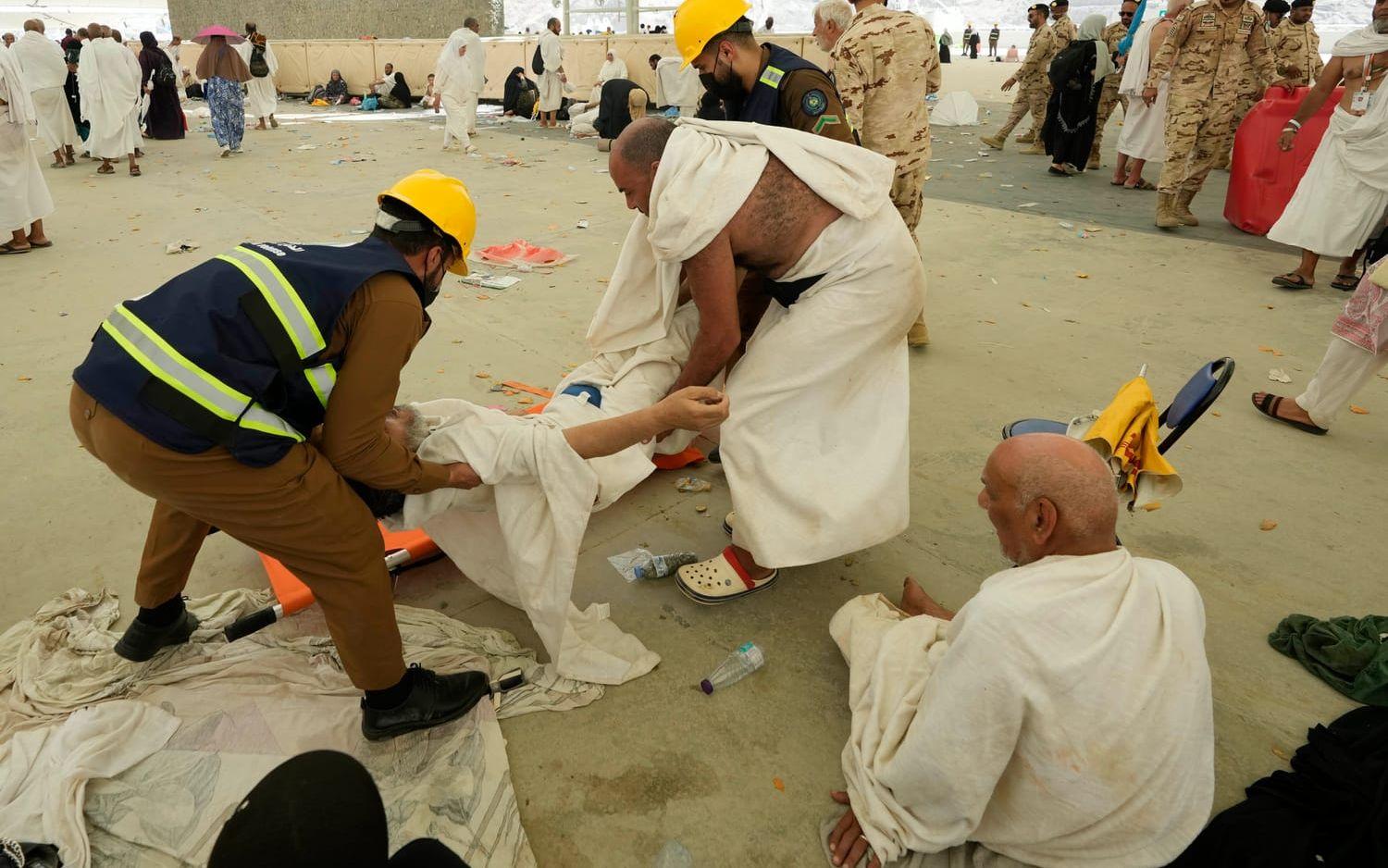 En man som kollapsat i värmen får hjälp av vårdpersonal i Mina, nära Mecka, i Saudiarabien.