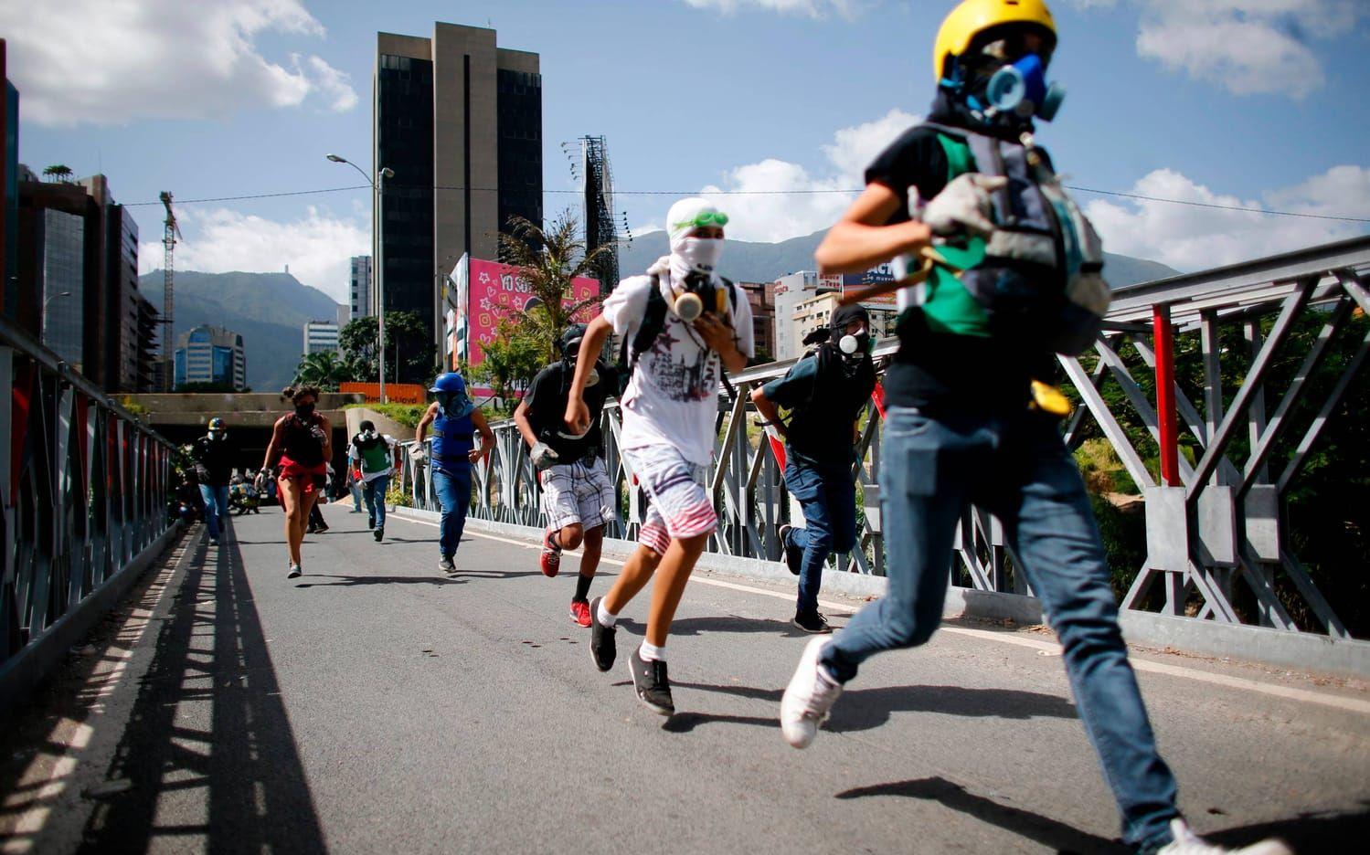 Anti-regeringsdemonstranter vid en protest mot Venezuelas president Nicolas Maduro i Caracas. Bild: TT, AP