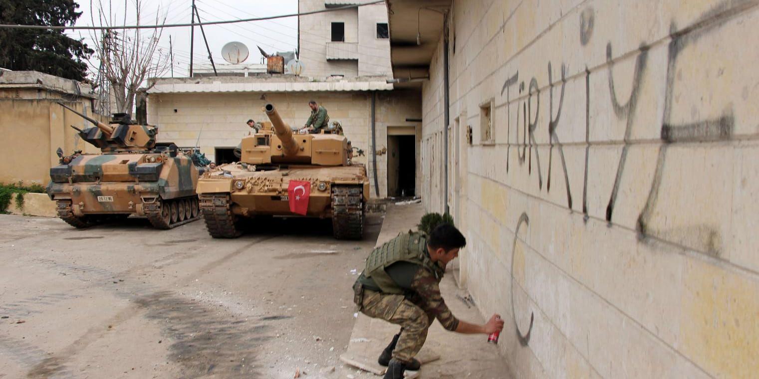 En turkisk soldat skriver "Turkiet" på en vägg i Afrin, sedan president Erdogan meddelat att turkiska styrkor och allierade syriska milisgrupper tagit kontrollen över stadens centrala delar.