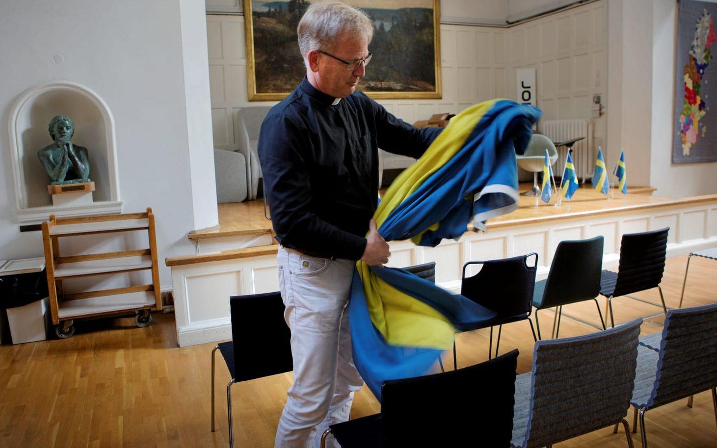 Eric Muhl, kyrkoherde på Svenska Kyrkan i London, viker ihop flaggor som ambassaden har lånat. 