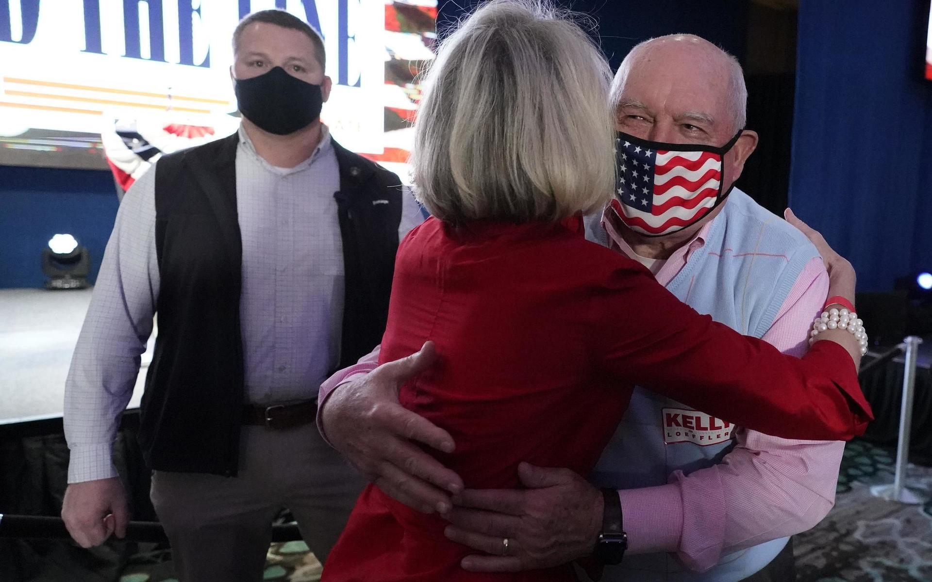 USA:s jordbruksminister Sonny Perdue, till höger, och kusin till David Perdue kramar en supporter vid en republikansk valvaka under valet till senaten.