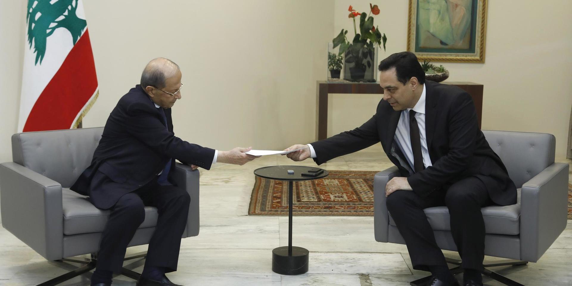 Libanons premiärminister Hassan Diab, till vänster, överräcker regeringens avgångsansökan till president Michel Aoun. 