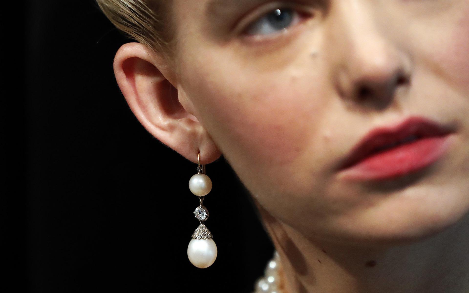 En modell visar upp Marie Antoinettes pärl- och diamantörhängen på Sotheby&apos;s i London under fredagen. 