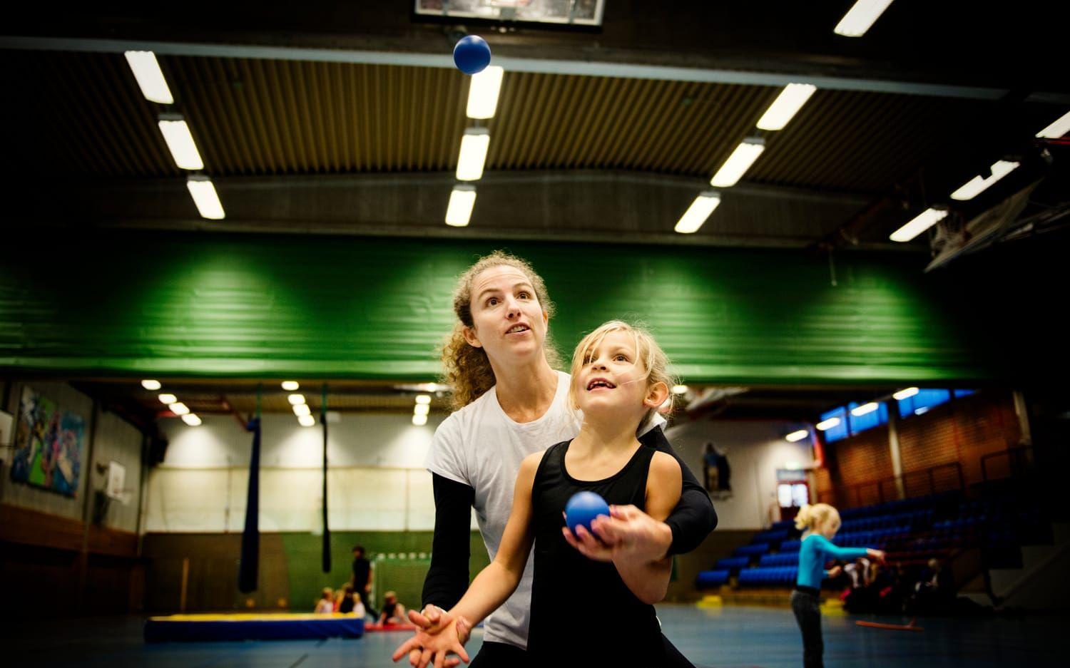 Elin Lütke från Cirkus Unik hjälper Alice Wahlberg, 7 år att jonglera.