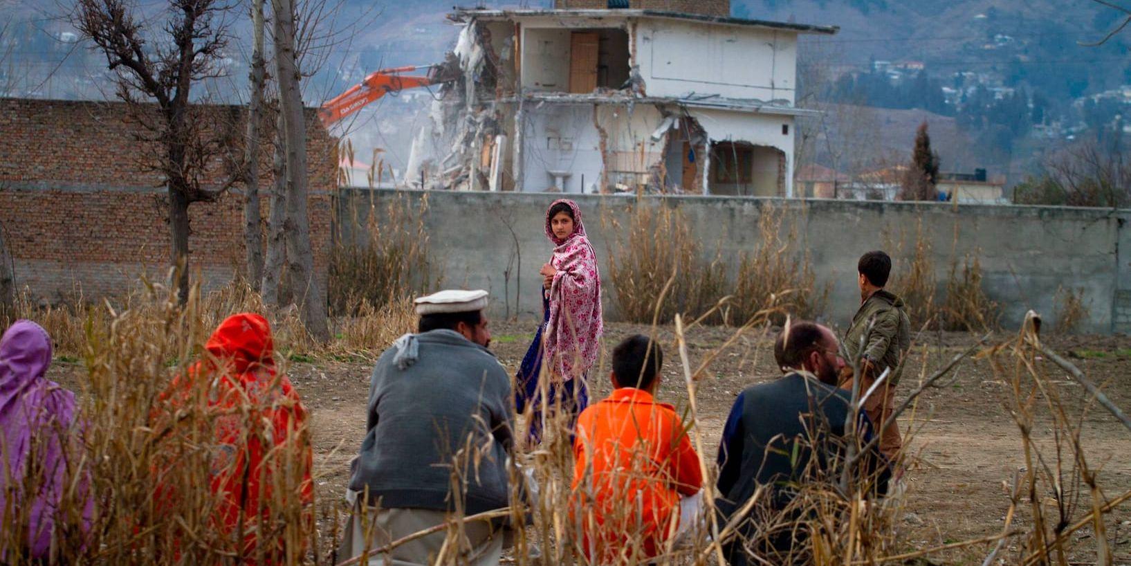 En pakistansk familj betraktar Usama bin Ladins förstörda hem i Abbottabad. Arkivbild.