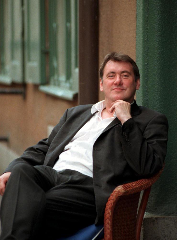 Göran Forsmark sittande i stol vid husvägg 1997.