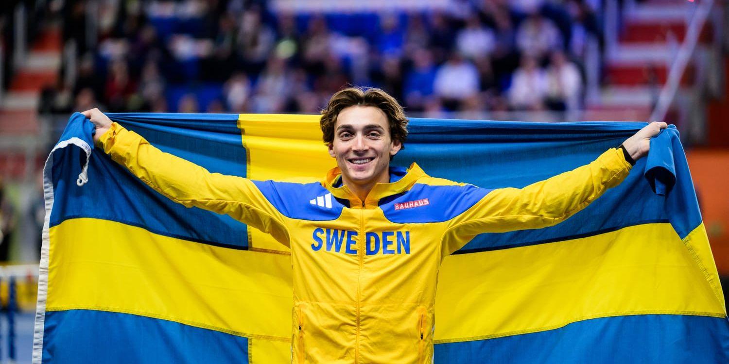 Armand Duplantis håller upp en svensk flagga.