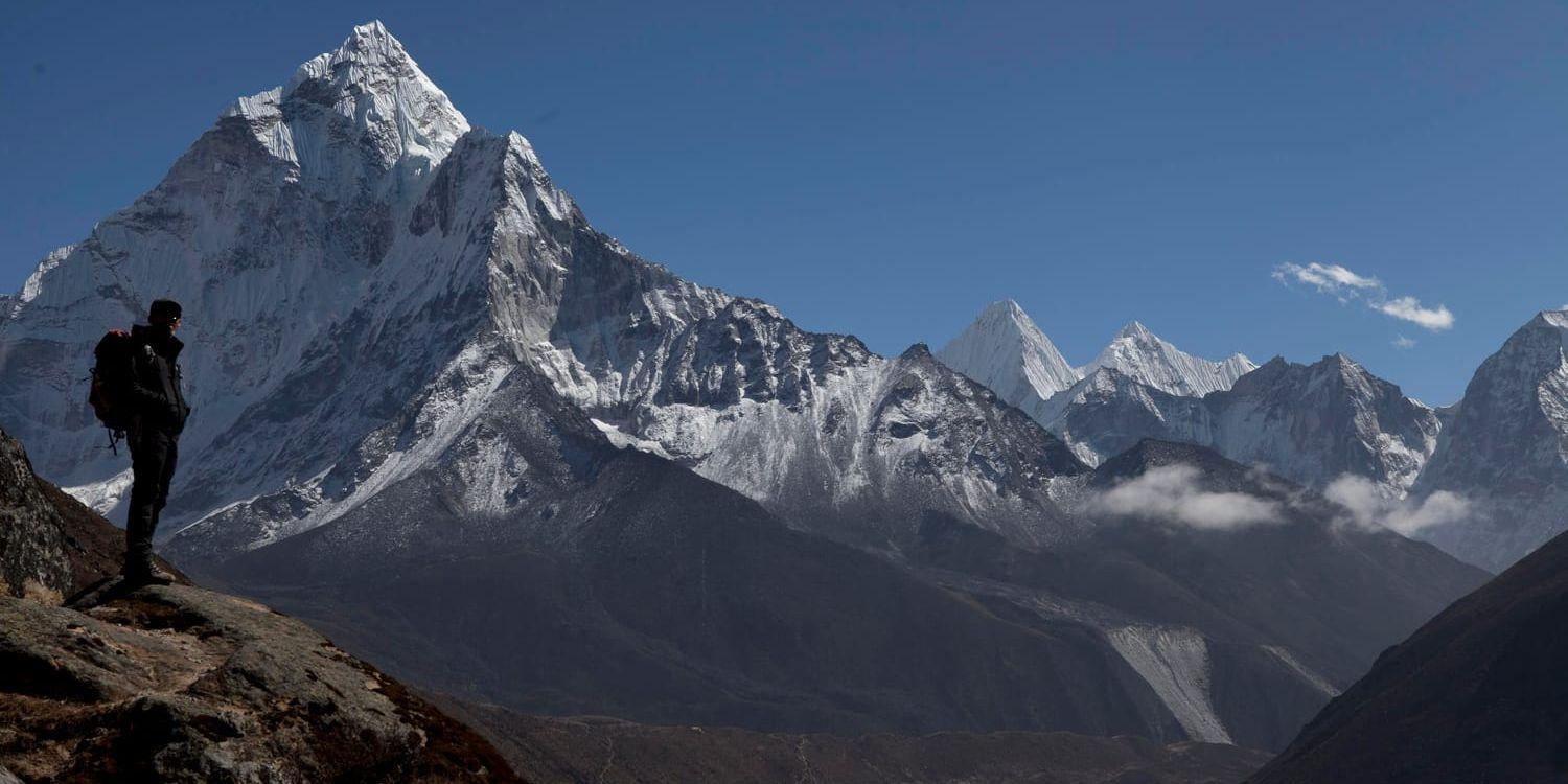 En klättrare tar en paus på väg upp på Mount Everest och tittar på utsikten. Arkivbild.
