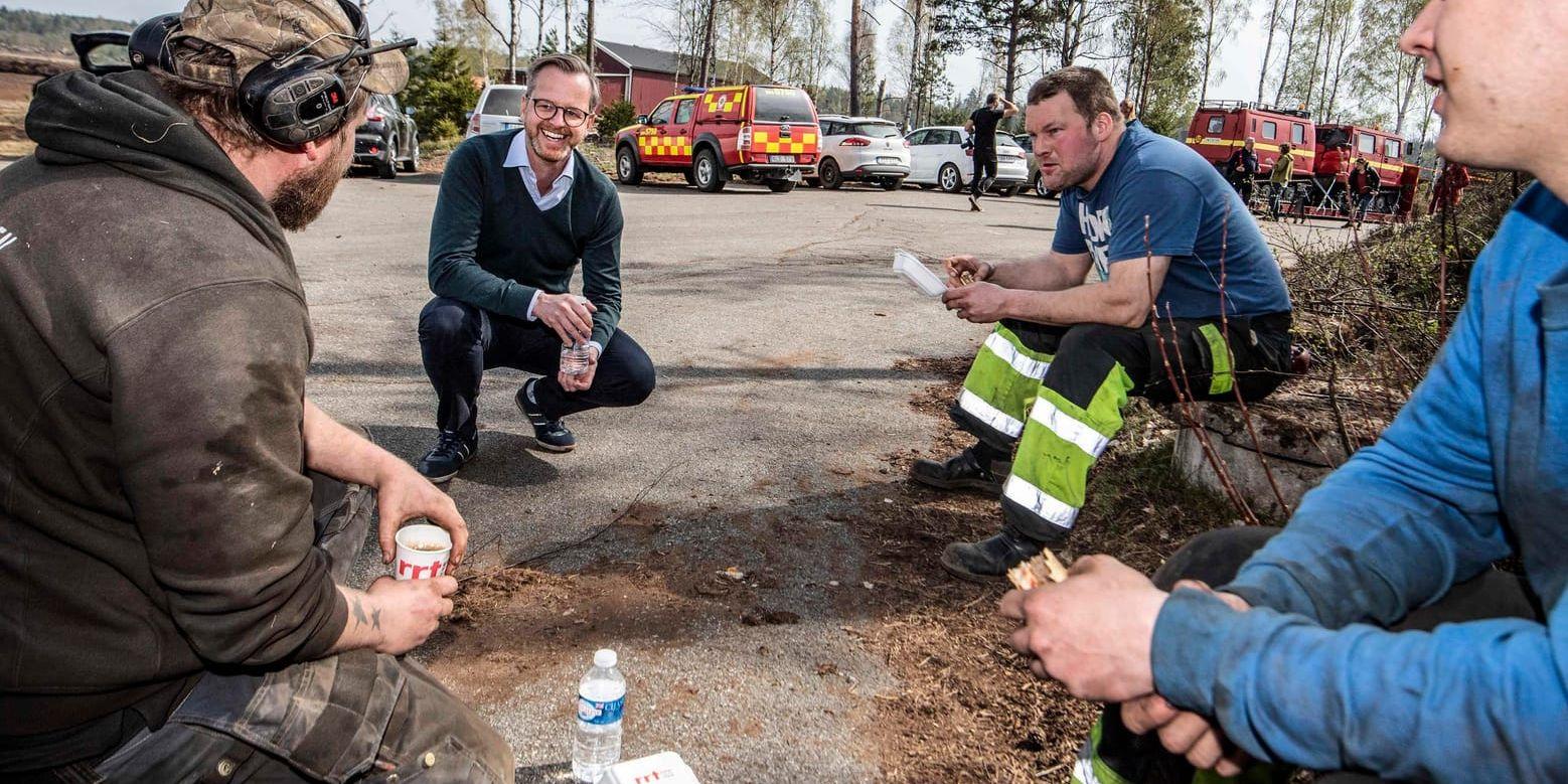 Inrikesminister Mikael Damberg samtalar med Peter Svensson, Johan Svensson och Robin Persson, som hjälper till med skogsbrandsläckningen utanför Hästveda.