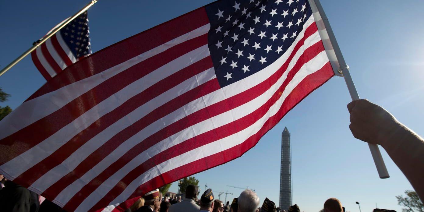 En flagga hålls upp vid ett möte för USA:s aktiva och pensionerade försvarsanställda i Washington DC 2013.
