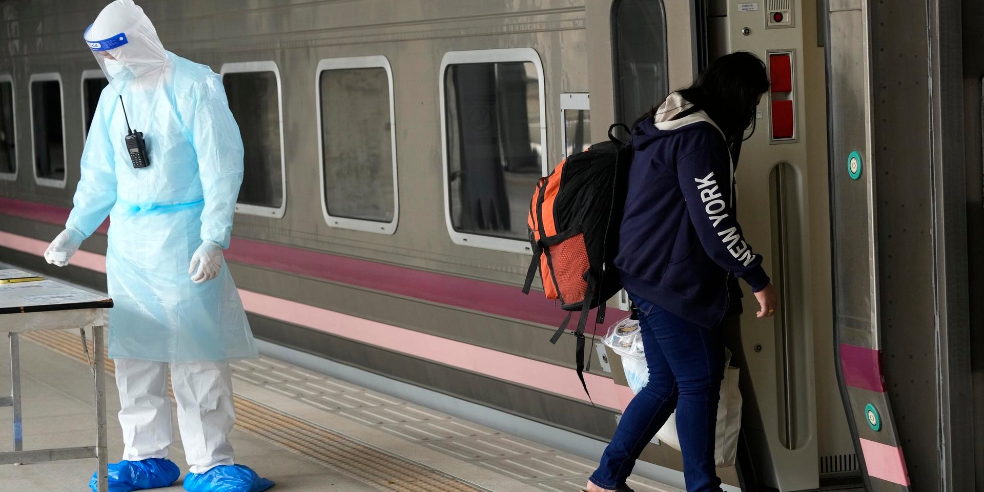 En covid-patient går ombord på ett tåg i Rangsit, för att resa till sin hemstad. De thailändska myndigheterna började transportera sjuka från Bangkok den 27 juli.