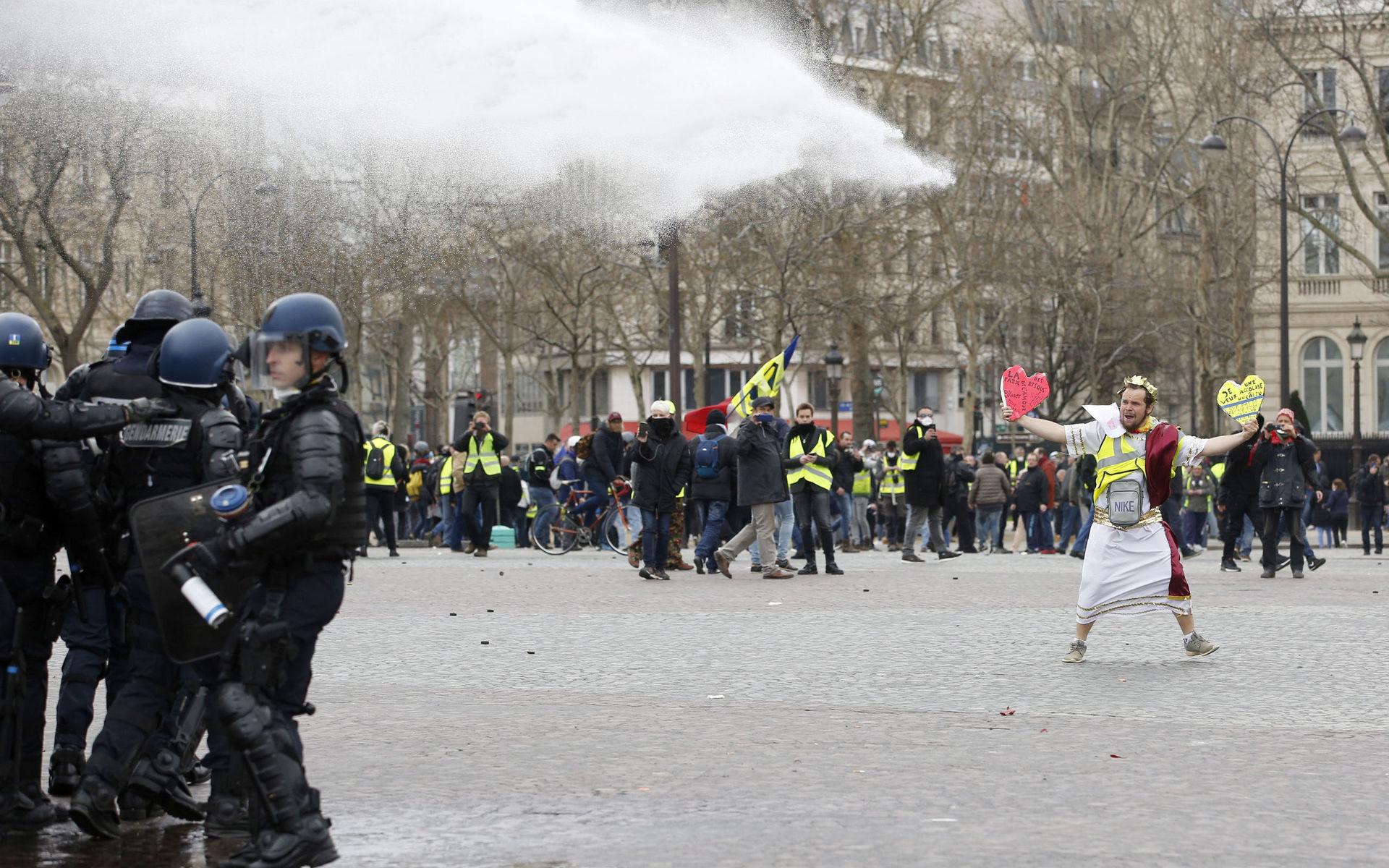 En demonstrant möter polisens vattenkanoner.