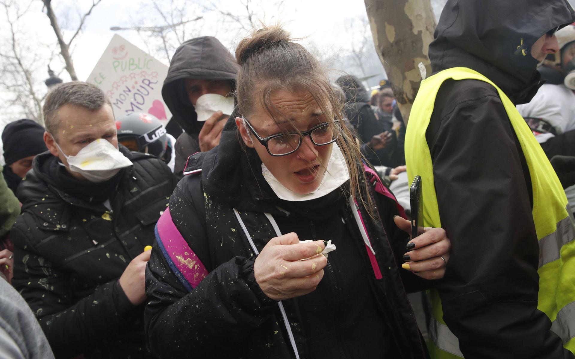 Demonstranter tar en paus efter att ha fått tårgas i ögonen.