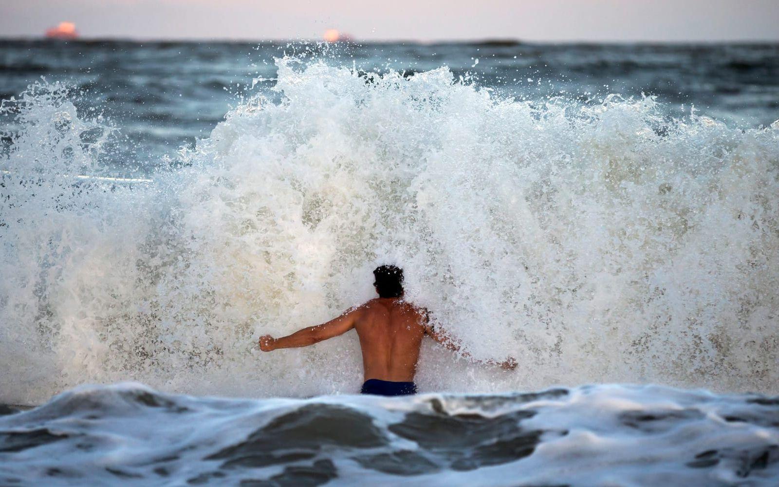 Surfaren Andrew Vanotteren möter vågorna som han säger har blivit större varje dag stormen närmat sig.