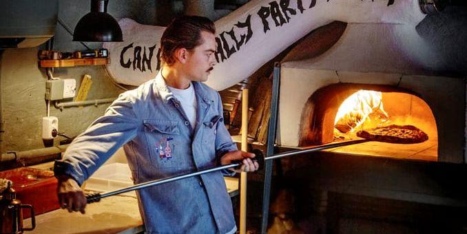 Gustaf Havner tar ut en pizza från Bovs vedeldade ugn.