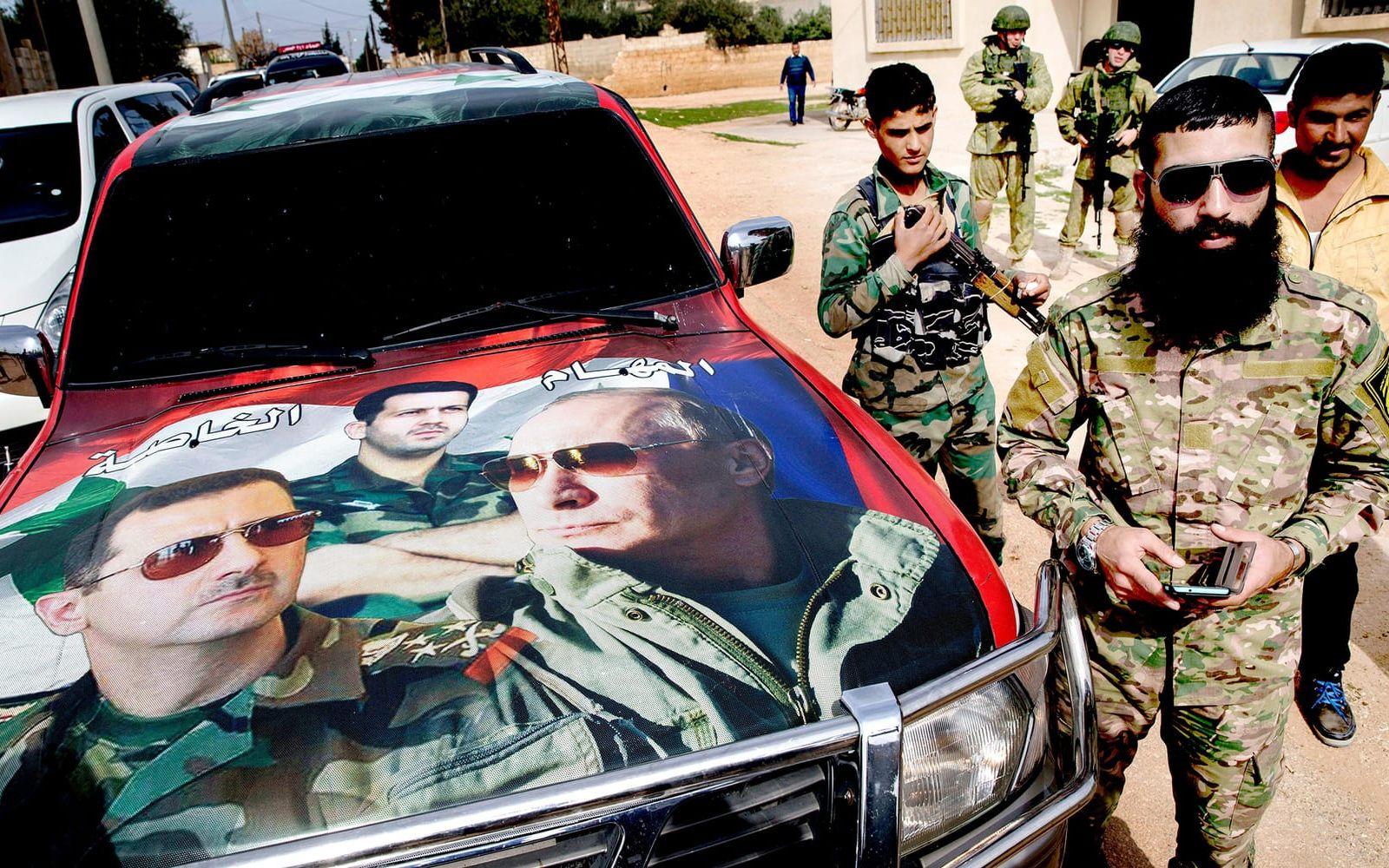 Illustrationer på en motorhuv av Bashar al-Assad och Vladimir Putin. Den hårt pressade syriske diktatorn begärde hjälp för drygt ett år sedan kom Putin till undsättning. BILD: Pavel Golovkin