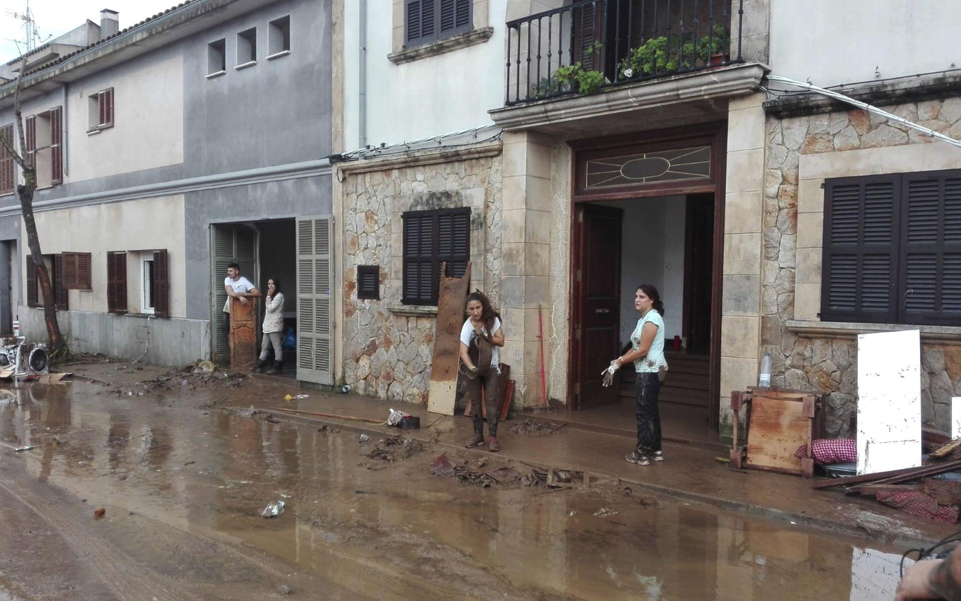 Boende försöker få bort lera och vatten från sina hem i Sant Llorenc. 