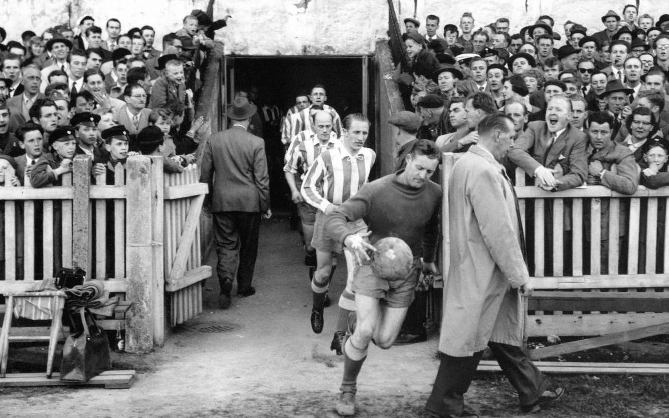 En majdag 1955 möttes IFK Göteborg och Gais på Gamla Ullevi inför över 30 000 åskådare. Det var en tid när ståplatspubliken fortfarande framträdde i slips och kostym. Främst springer Blåvitts målvakt Henry Andersson. 
