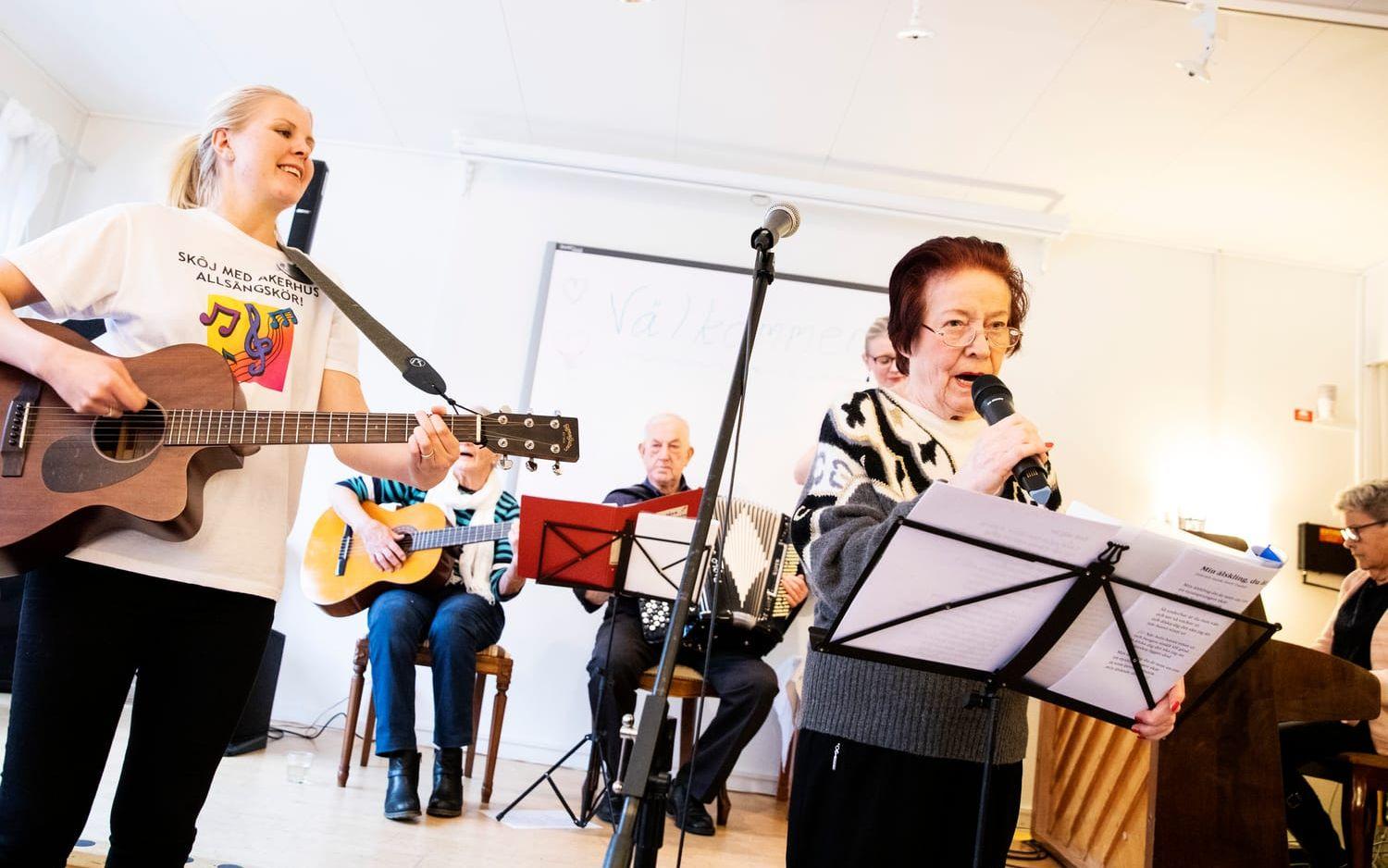 Äldrekonsulenten Stina Ekvall spelar gitarr och Synnöve Friman sjunger.