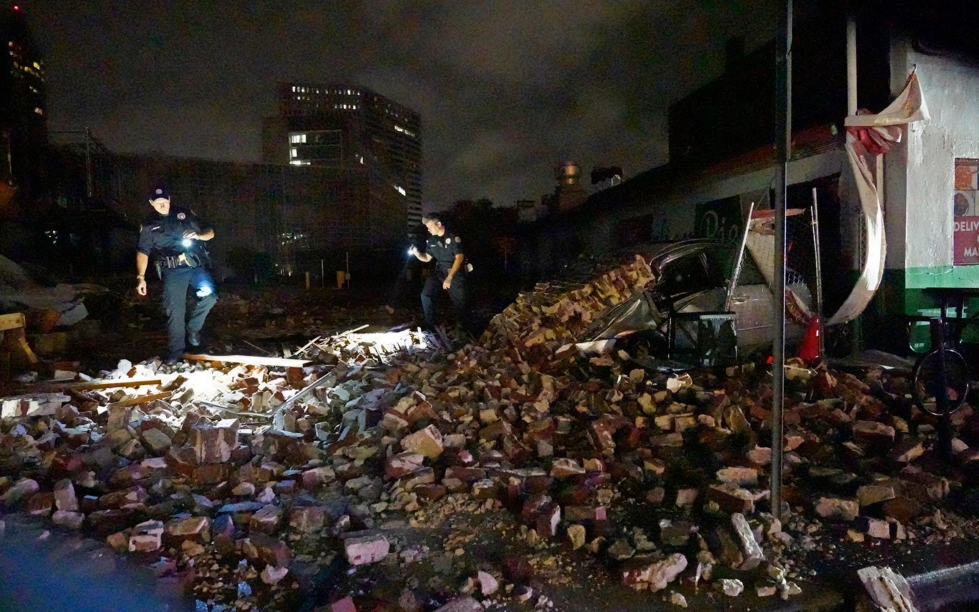 Polis i New Orleans ser över en byggnad som kollapsat under orkanens framfart.