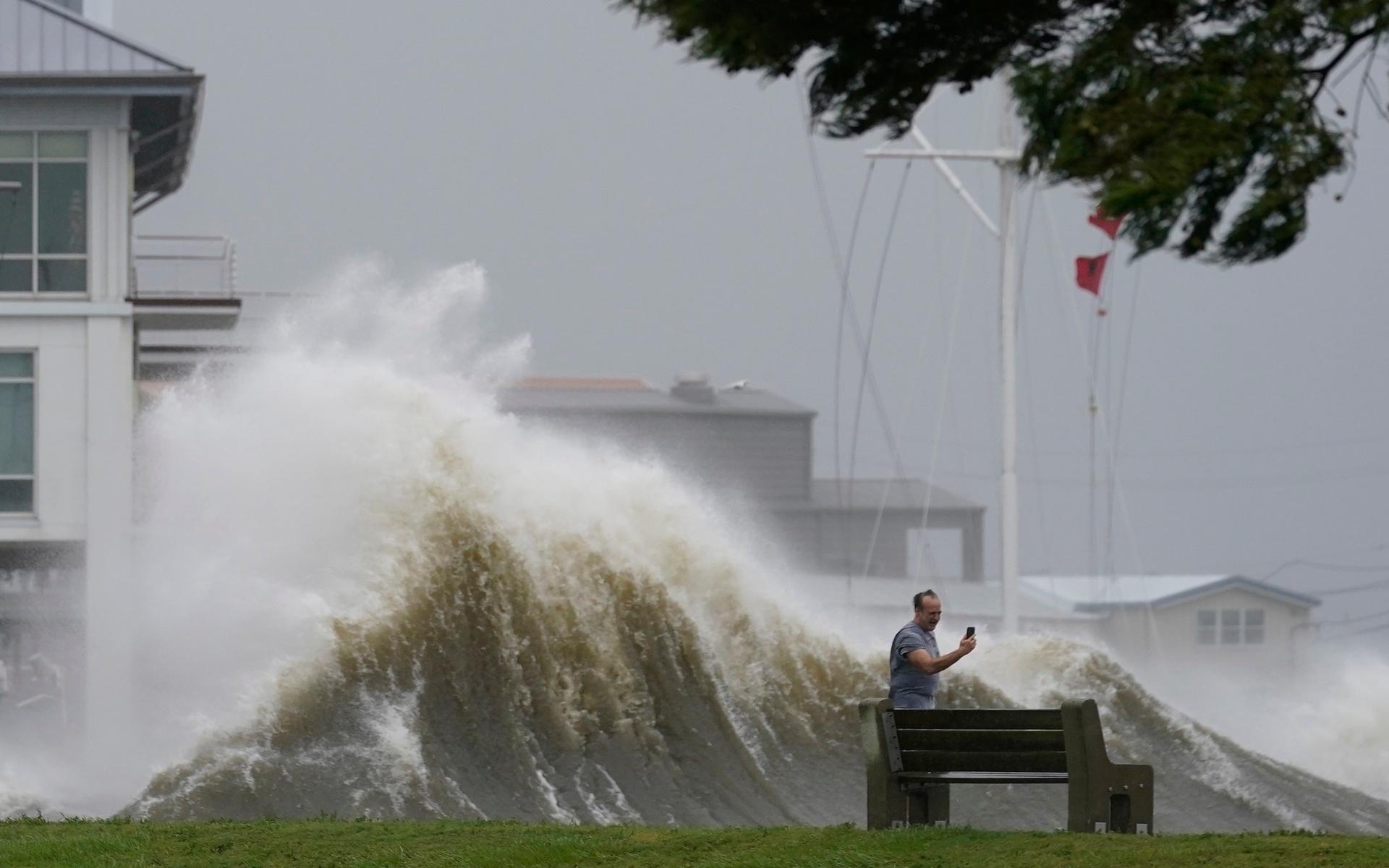 En man tar bilder vid Lake Pontchartrain när orkanen Ida närmar sig.