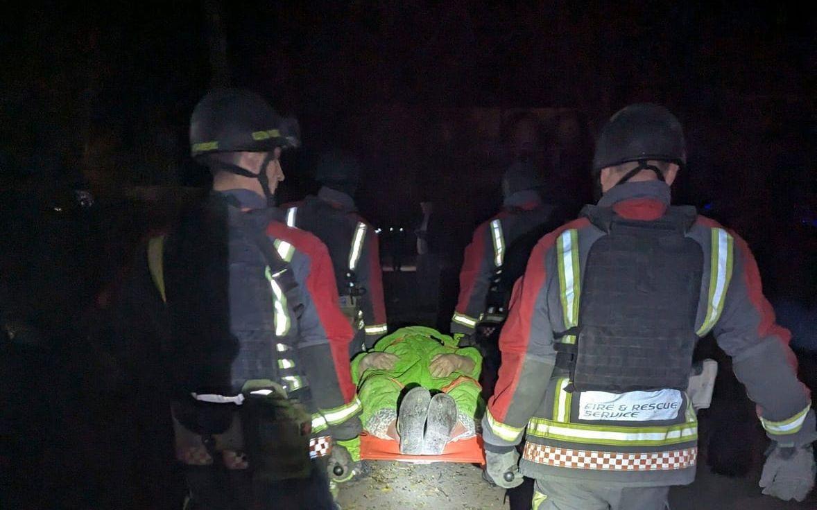 En skadad person bärs på bår efter nattens ryska attack mot Zaporizjzja.