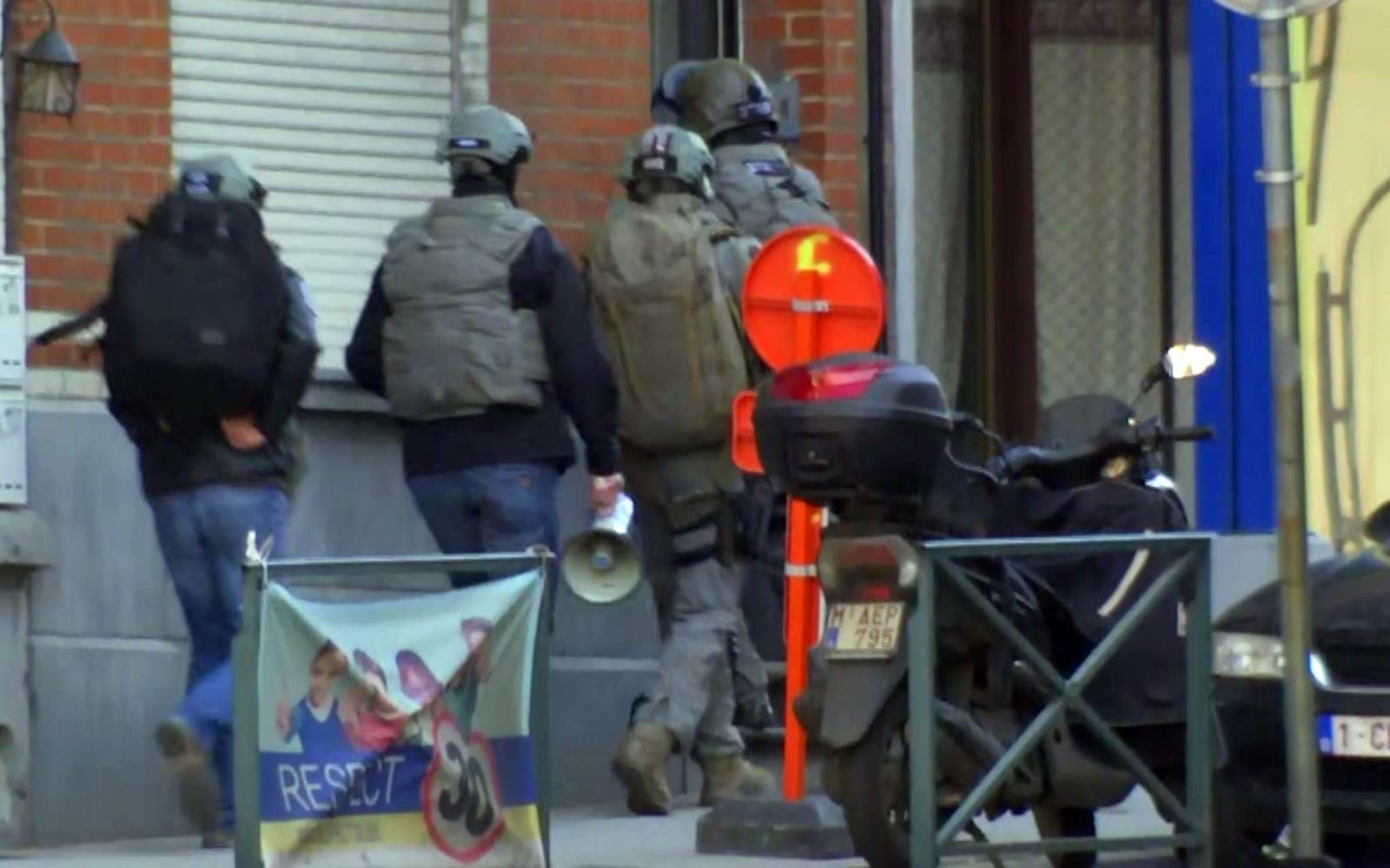 Belgisk insatspersonal tar sig in i en byggnad under den pågående polisinsatsen i Brysselförorten Vorst. FOTO: AP