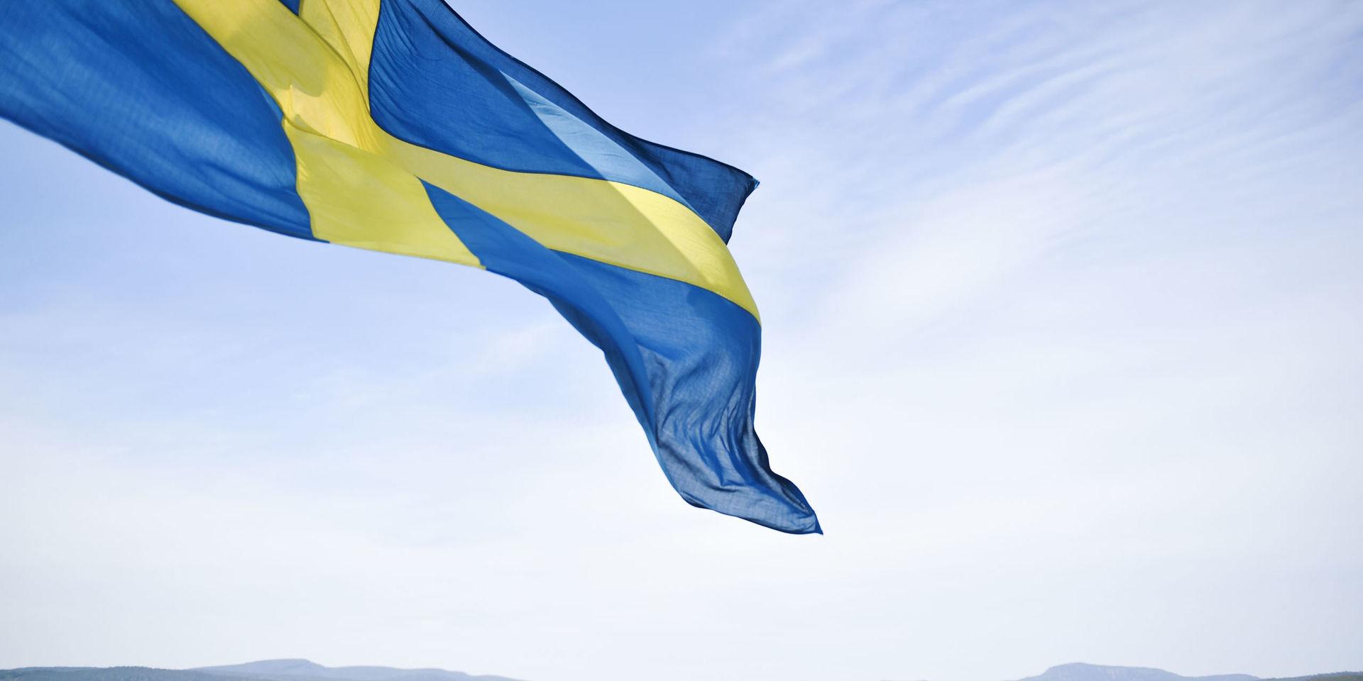 En svensk flagga blåser i vinden.