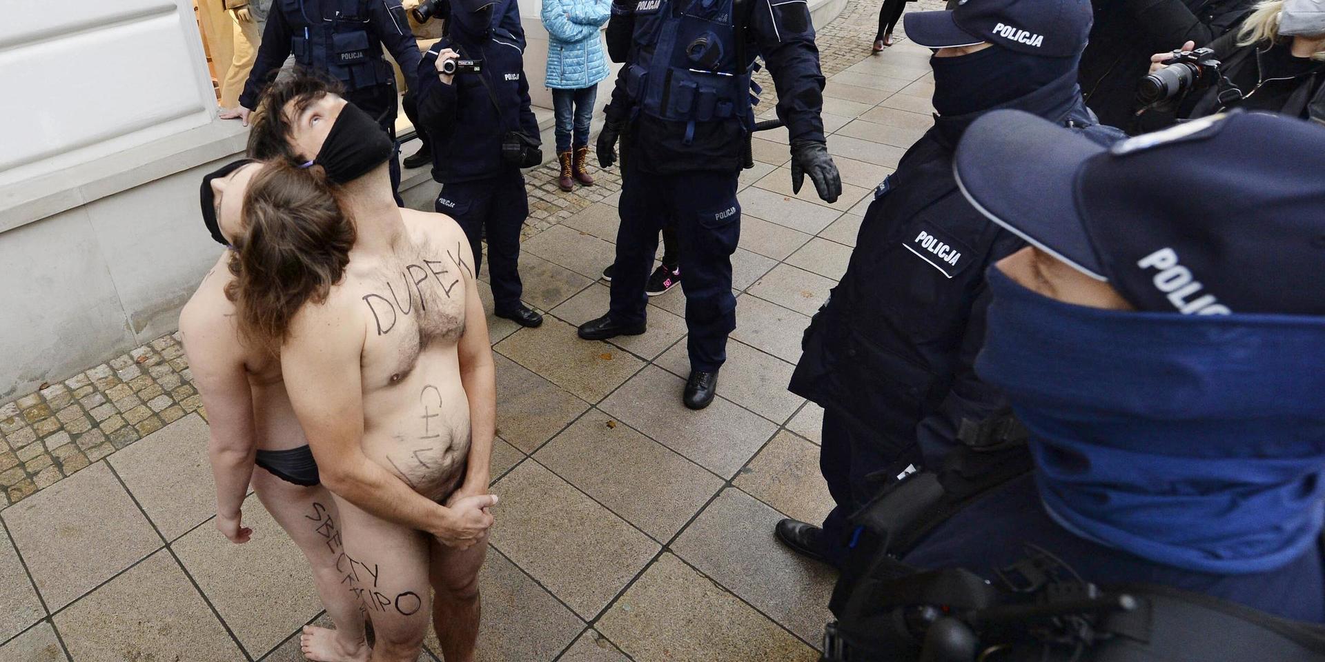 Poliser ingrep mot två aktivister som genomförde en demonstration för mänskliga friheter i Warszawa.