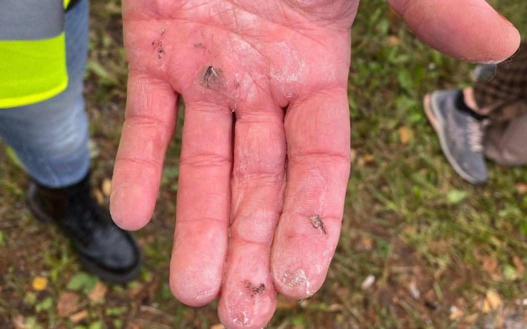 En av aktivisterna visar upp sin hand, som han limmat fast i en av körbanorna vid klimatprotesten på E4.