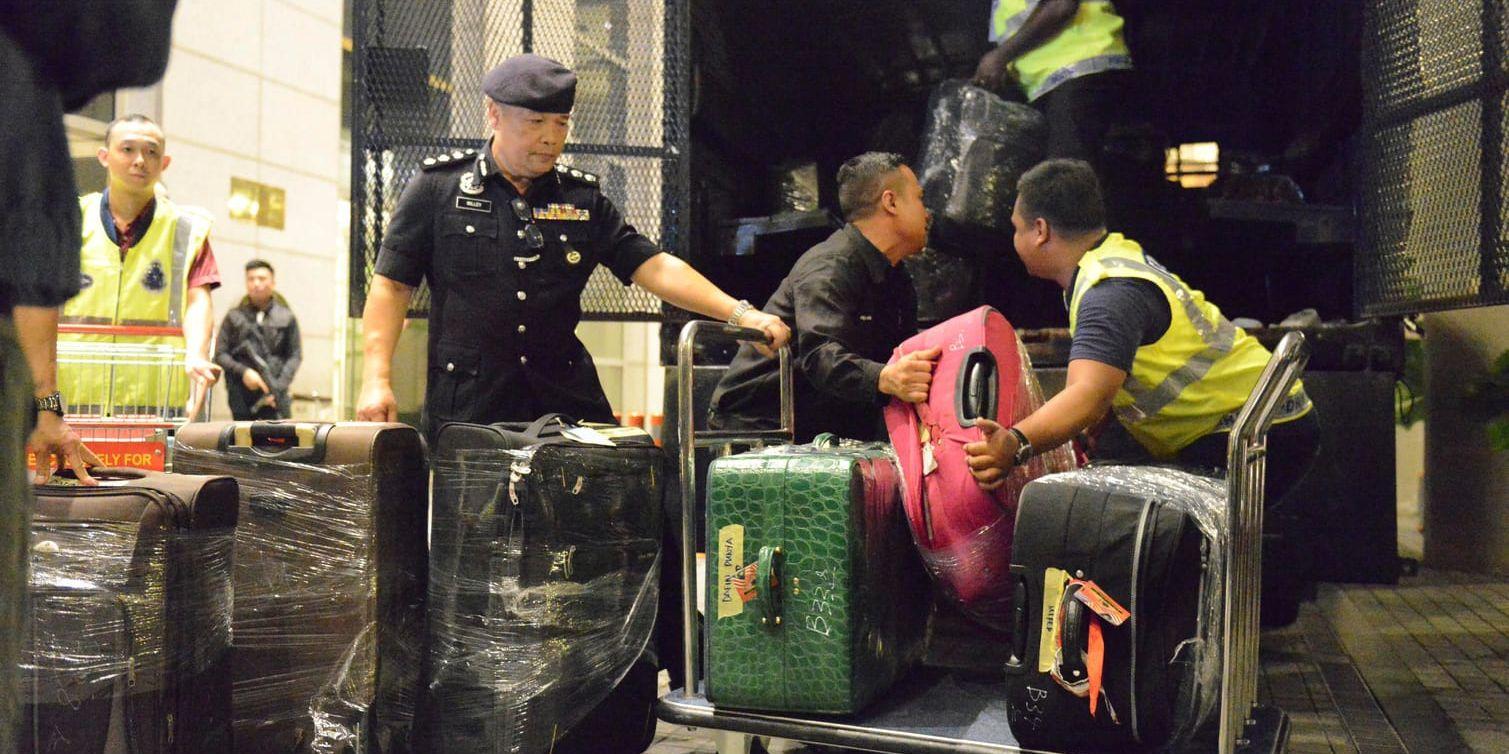 Polisen packar in beslagtagna föremål i en lastbil i Kuala Lumpur.