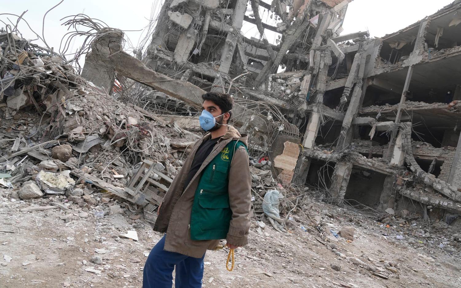 En frivillig räddningsarbetare utanför ett bostadshus i Teheran som träffades under ett anfall i söndags. Bilden togs på torsdagen. 