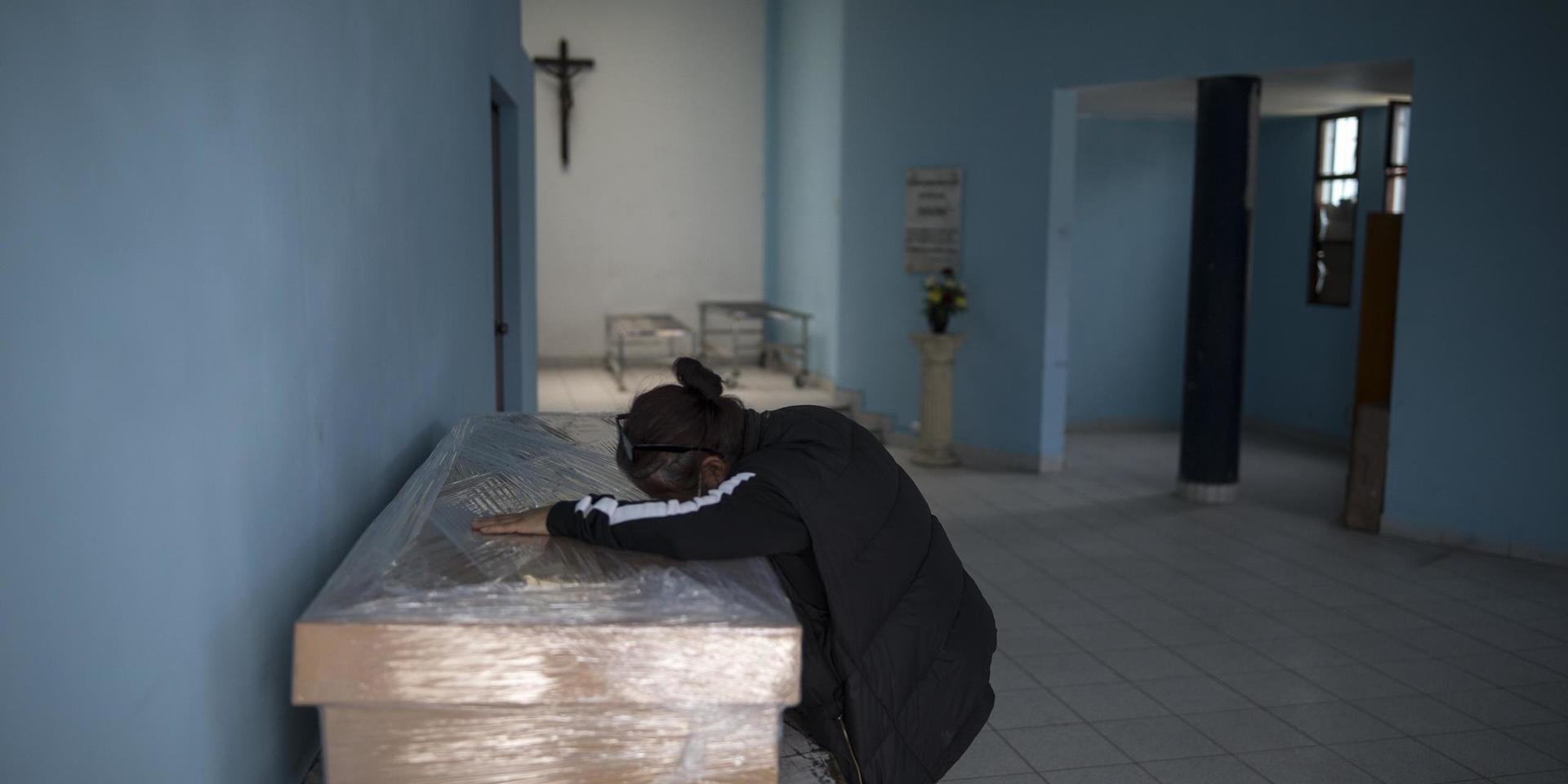 En änka sörjer sin make, som avlidit efter att ha insjuknat i covid-19, i Perus huvudstad Lima.