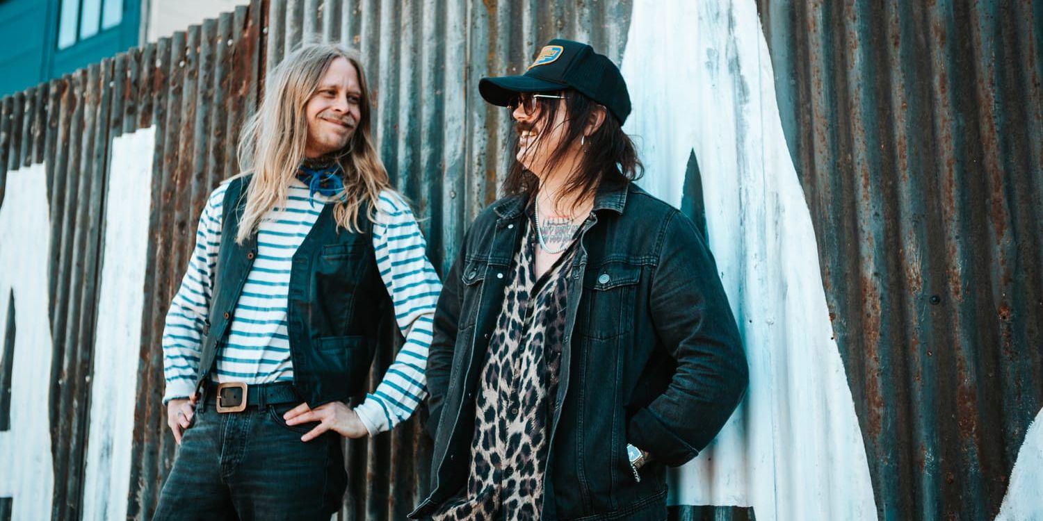 Arrangörerna står lutade mot en ruffig plåtvägg.