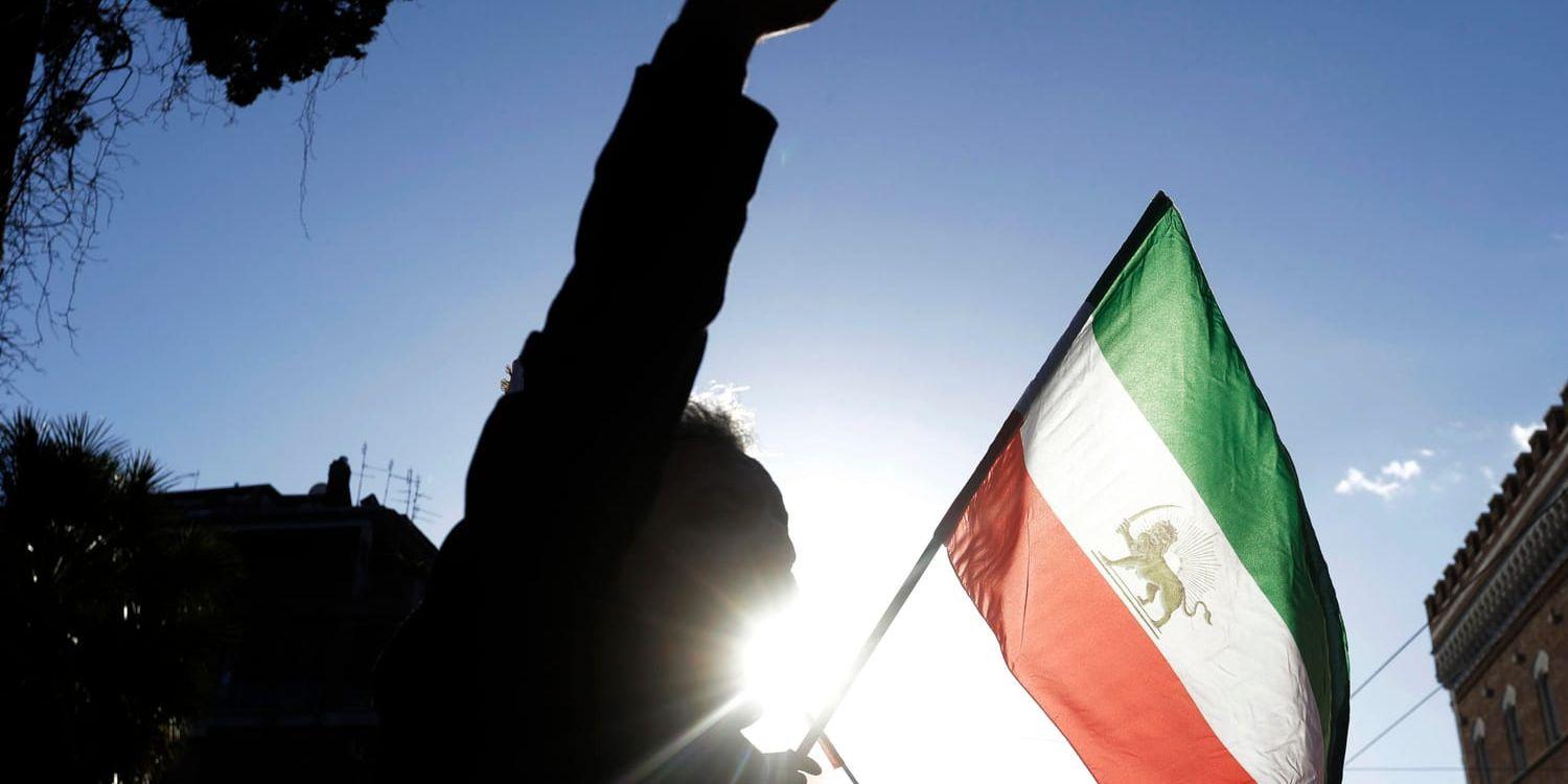 Den iranska flaggan hålls upp vid en demonstration. Arkivbild.