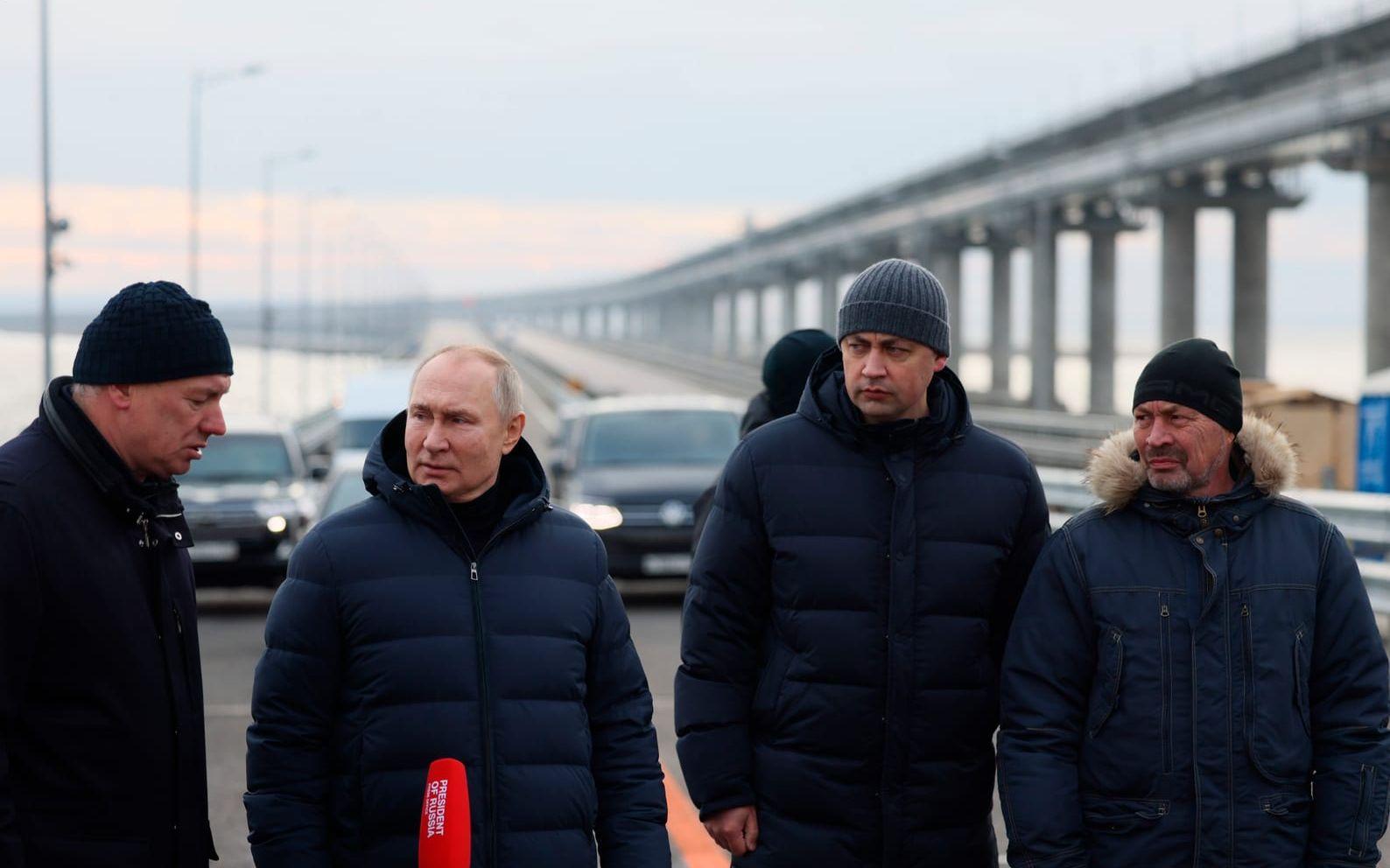 Rysslands president Vladimir Putin, näst till vänster, lyssnar på vice premiärminister Marat Chusnullin under brobesöket.