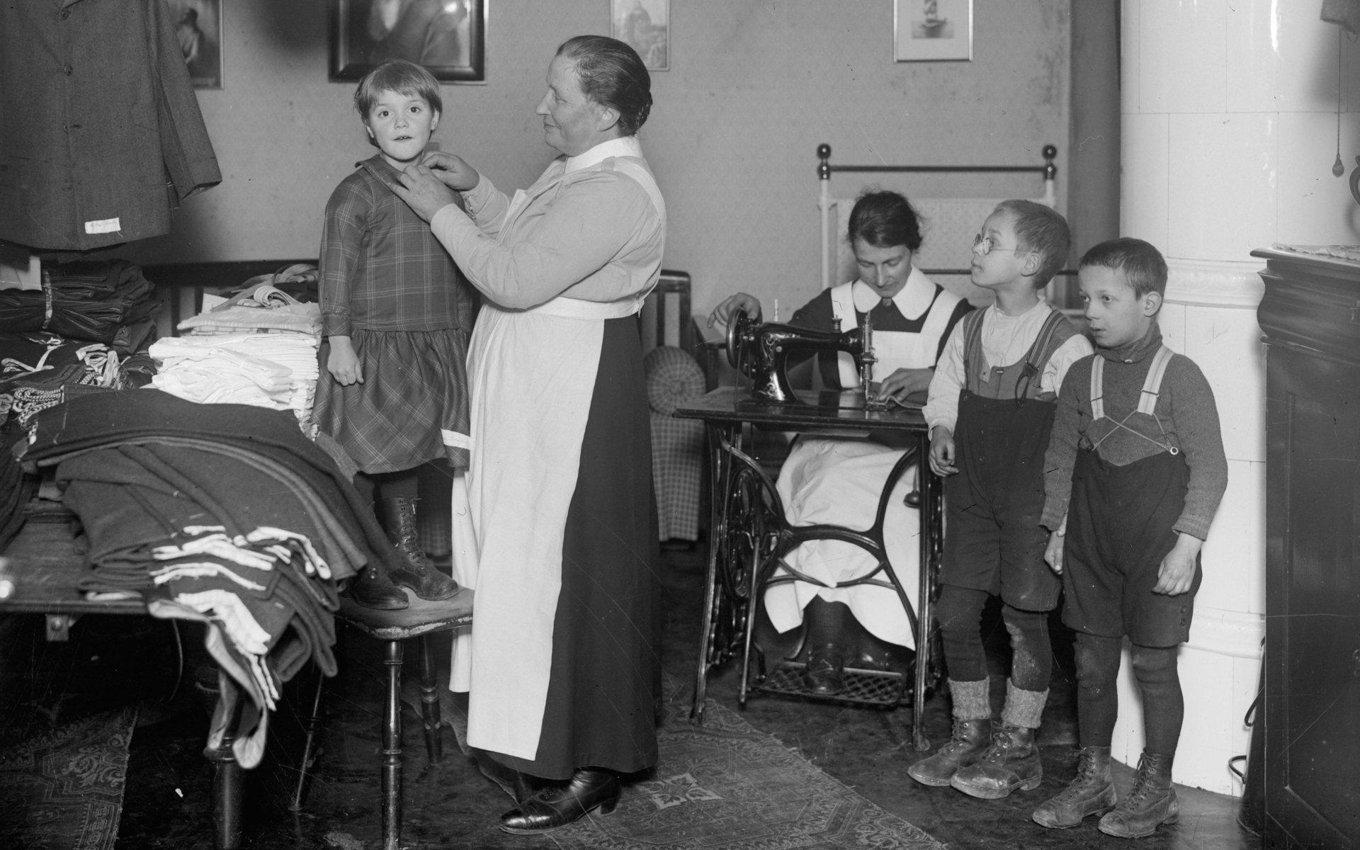 ”Slumsystrar” ger fattiga barn kläder till jul. Året år 1927. 