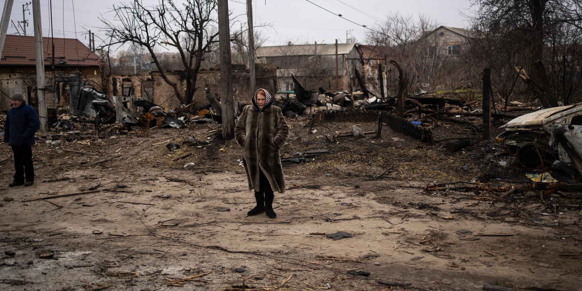 En kvinna blickar ut över förödelsen i Butja, utanför Kiev. Världen skakades av vittnesmålen från Butja om mord och övergrepp när Ryssland dragit sig tillbaka.