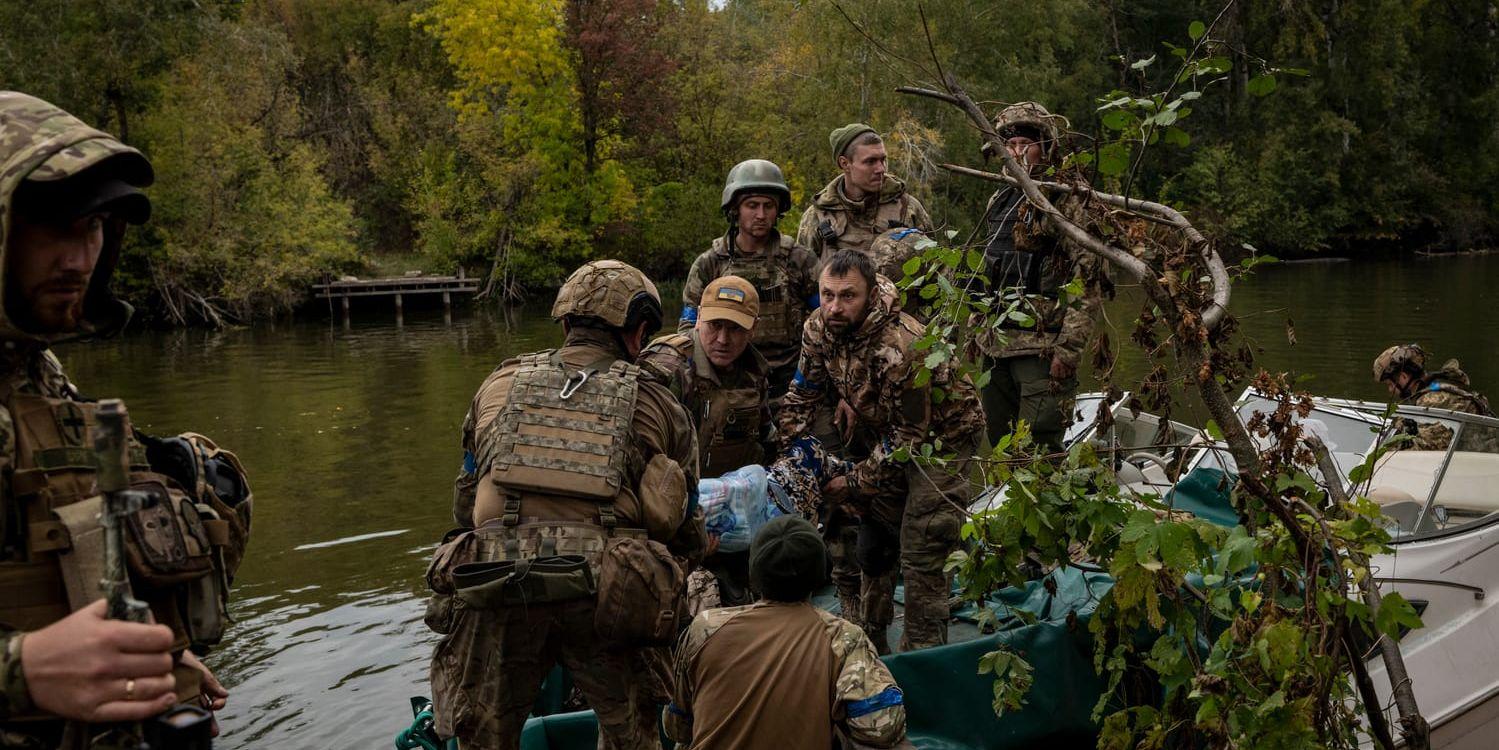 Ukrainska soldater lastar av utrustning från en båt på floden Donets nära Lyman.