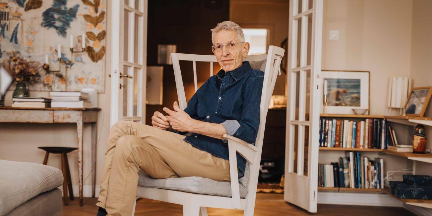 Nirvan Richter iklädd jeansskjorta och ljusa byxor, sittandes i en länstol. 